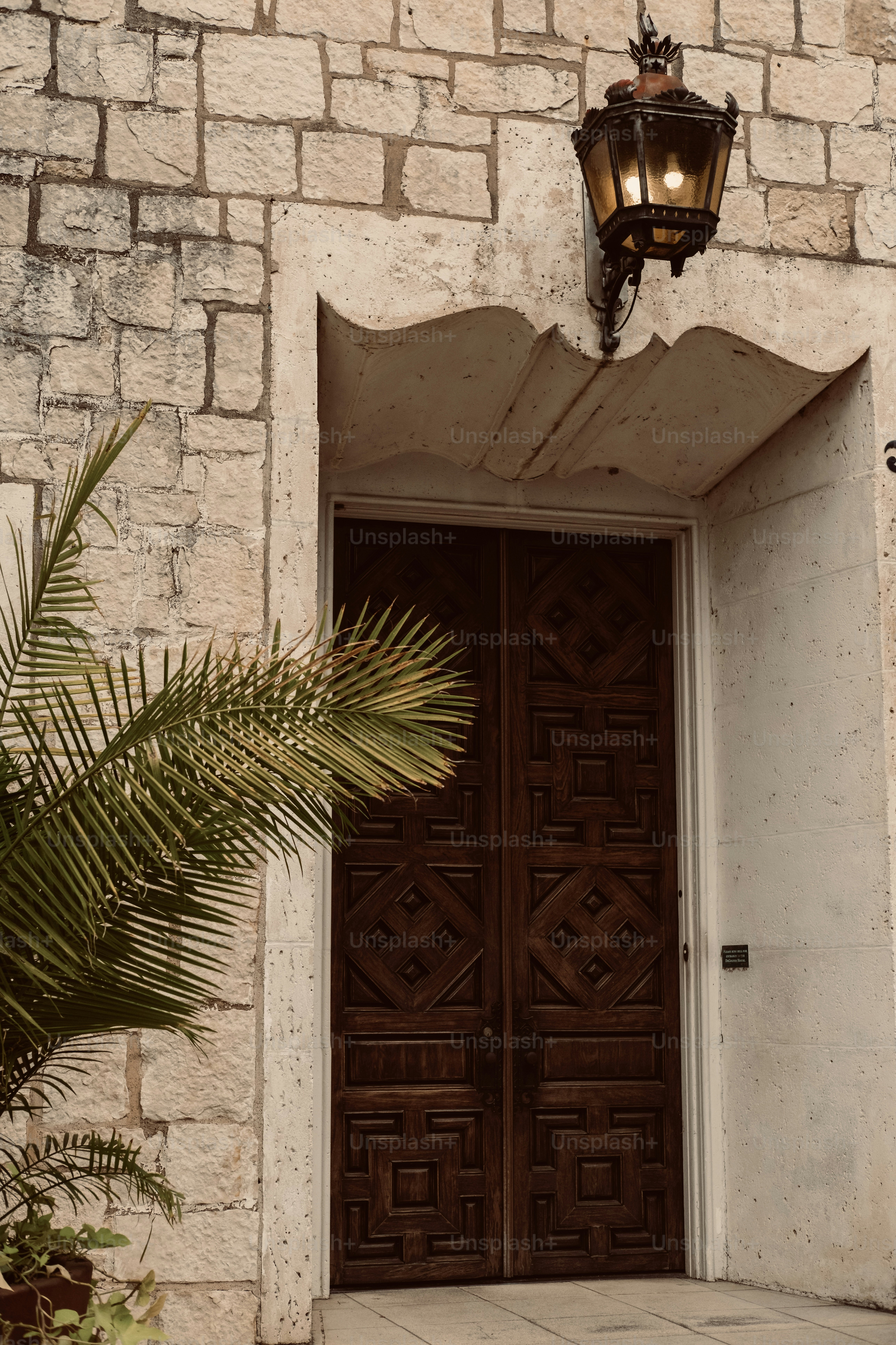 Puertas de madera ornamentadas debajo de una linterna vintage.