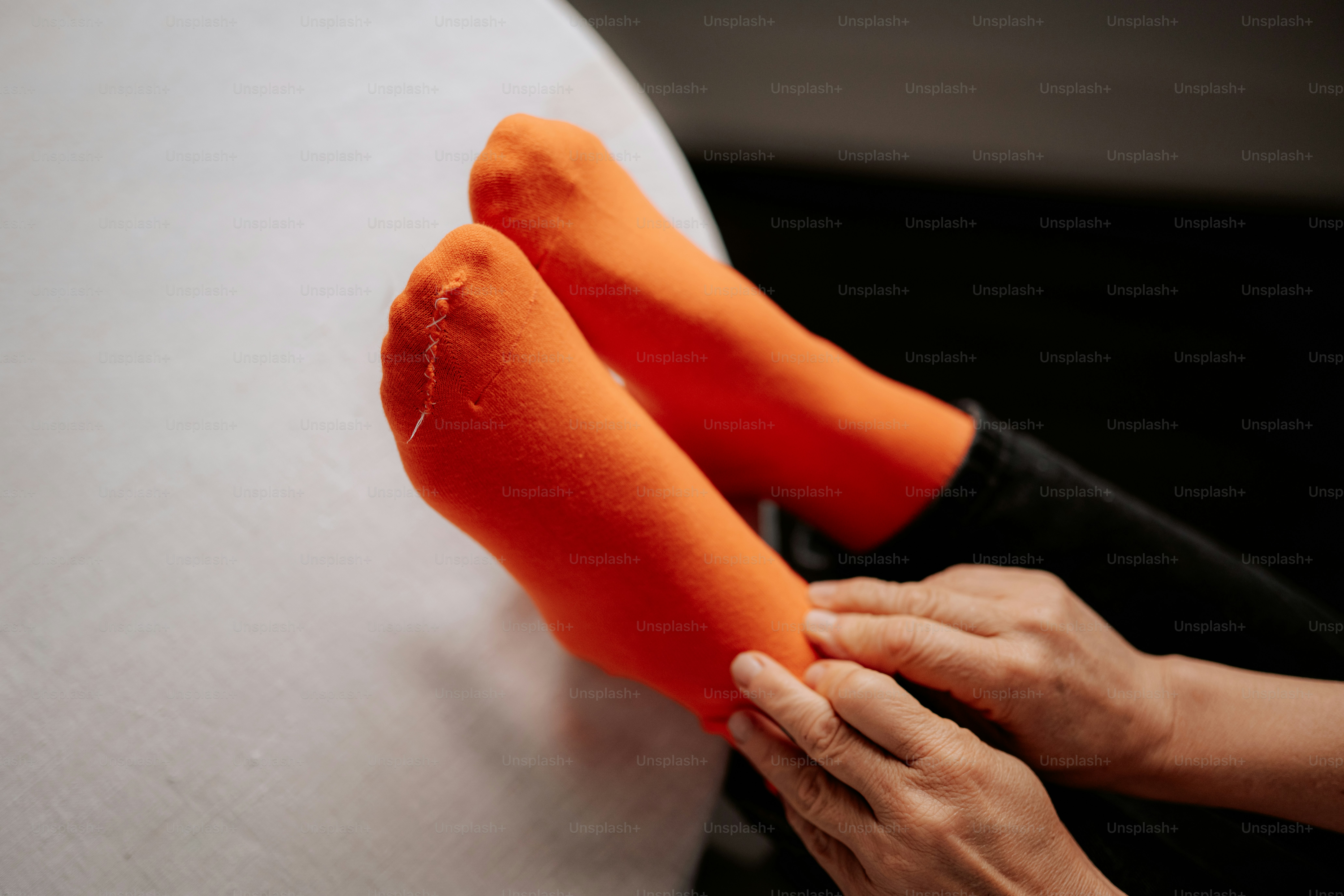 Person's feet wearing bright orange socks