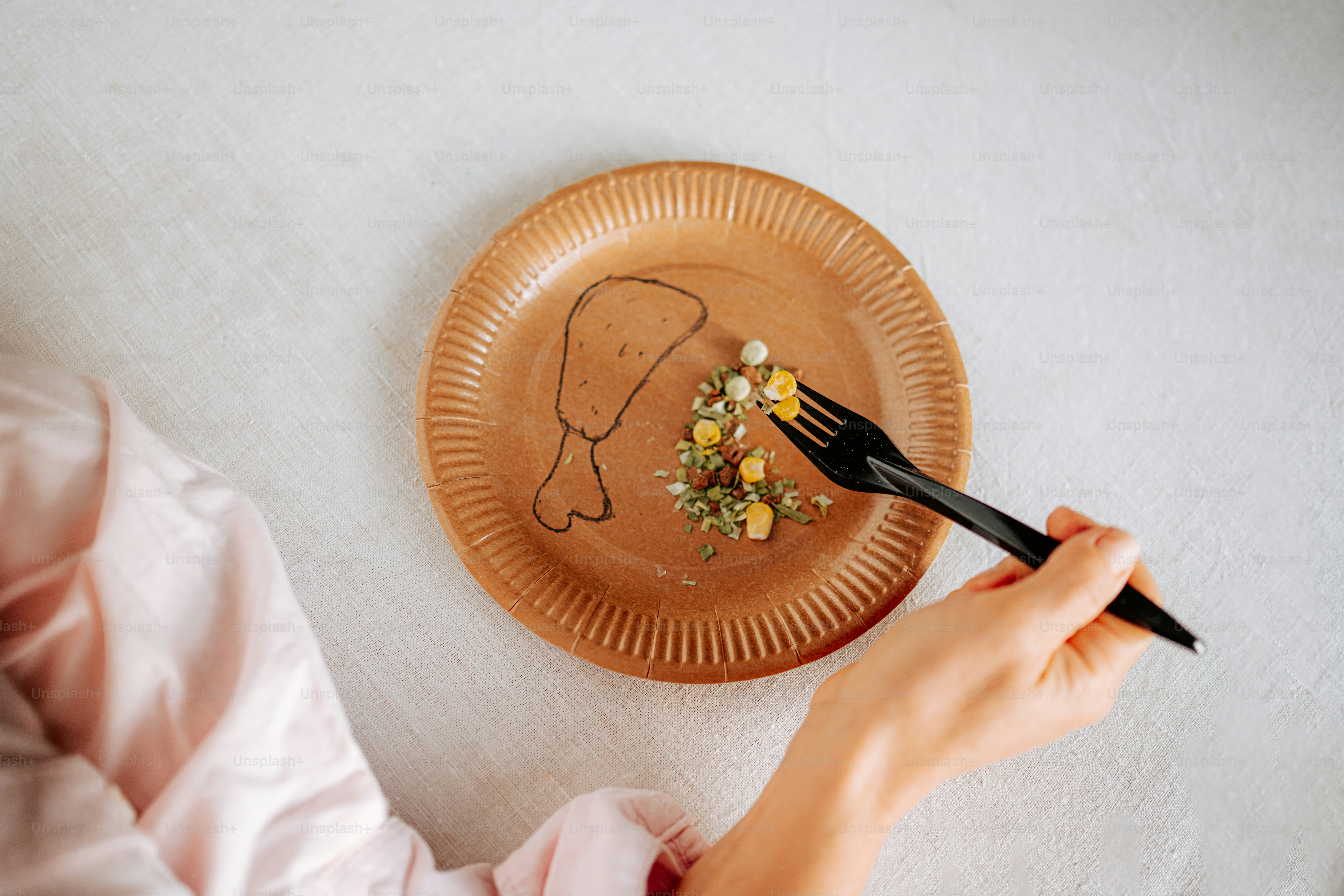 Person eating leftover food from a plate