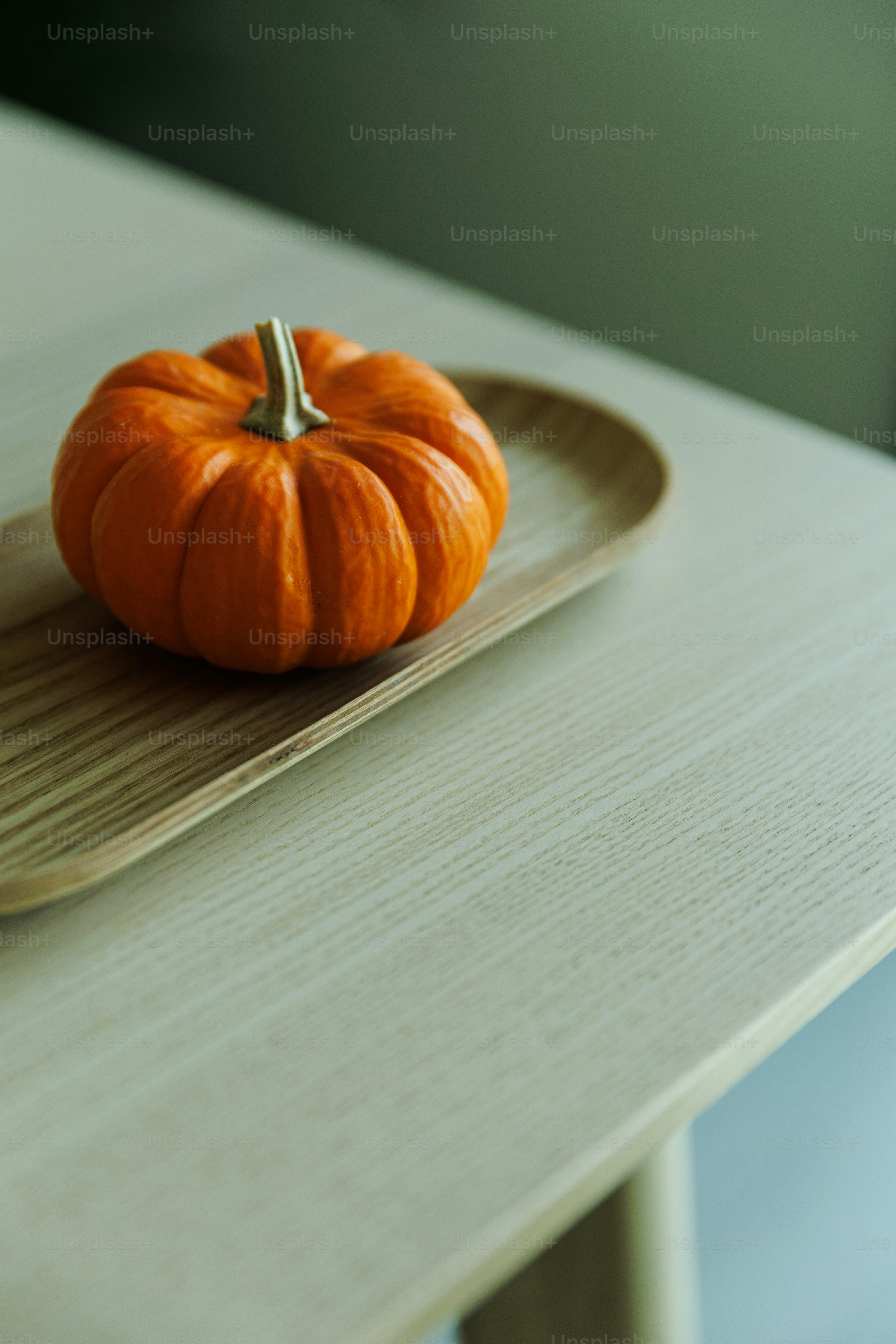 Small orange pumpkin on a wooden tray