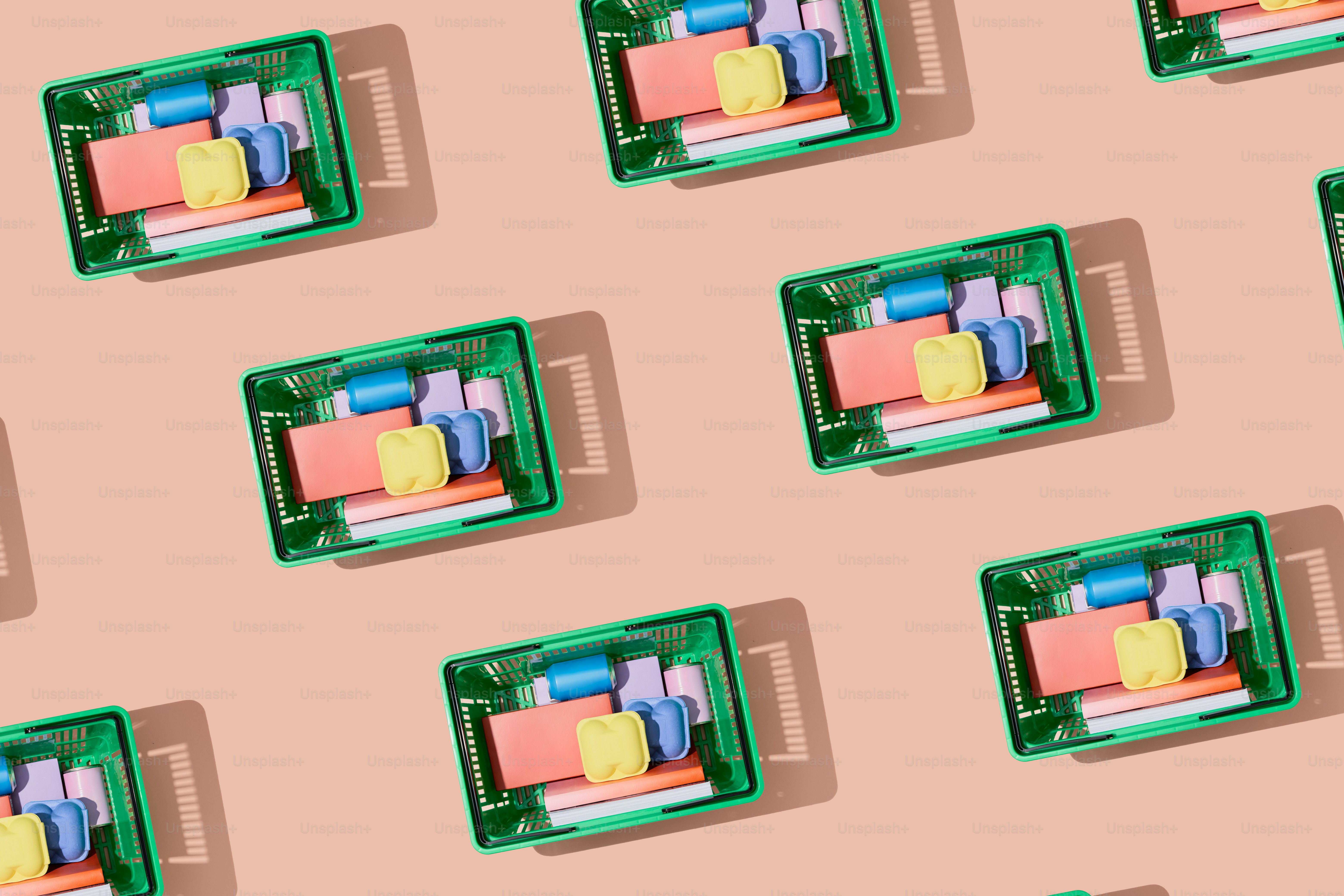 Green crates filled with colorful items on pink background