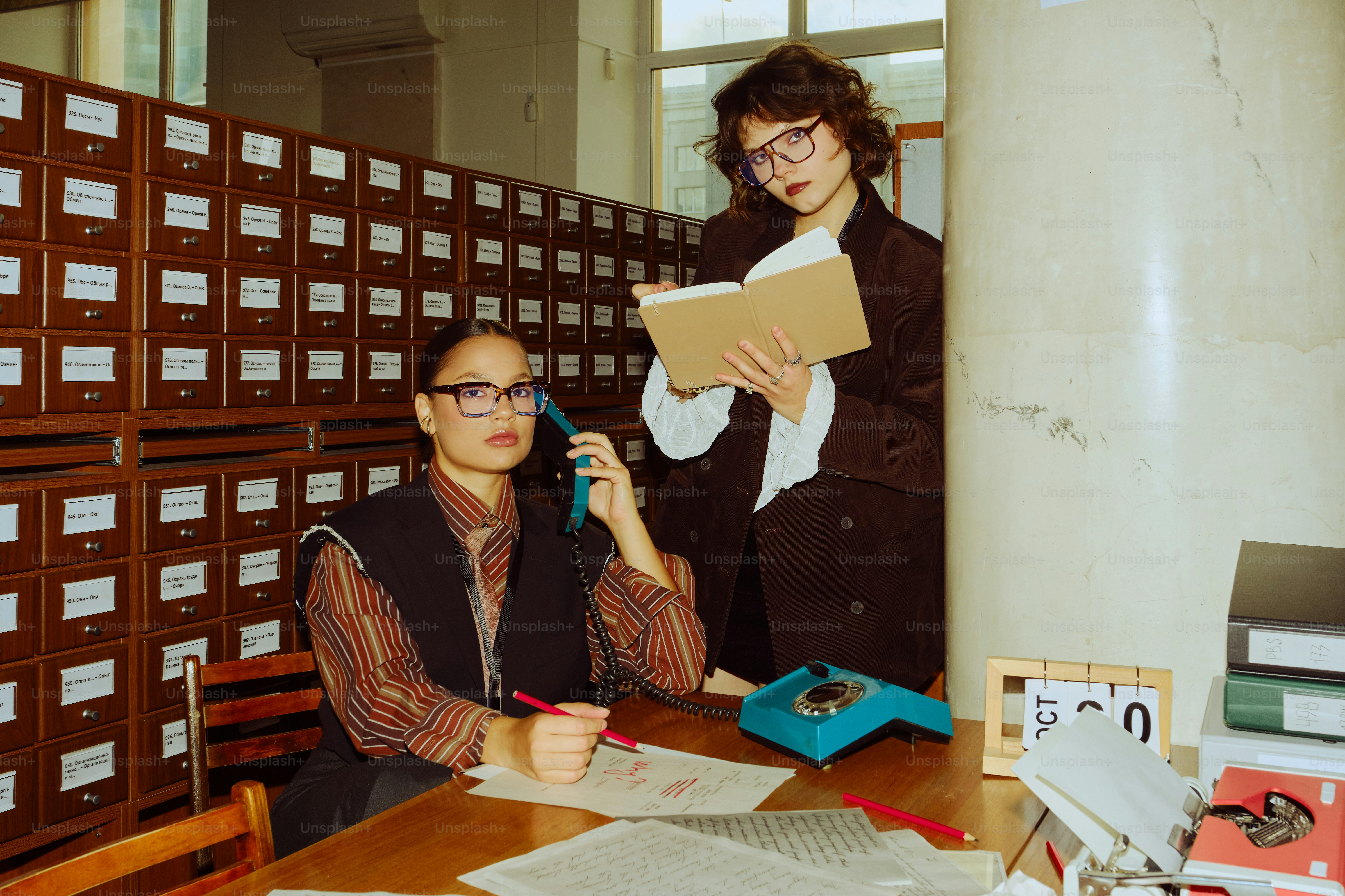 Two women working in a vintage library archive.
