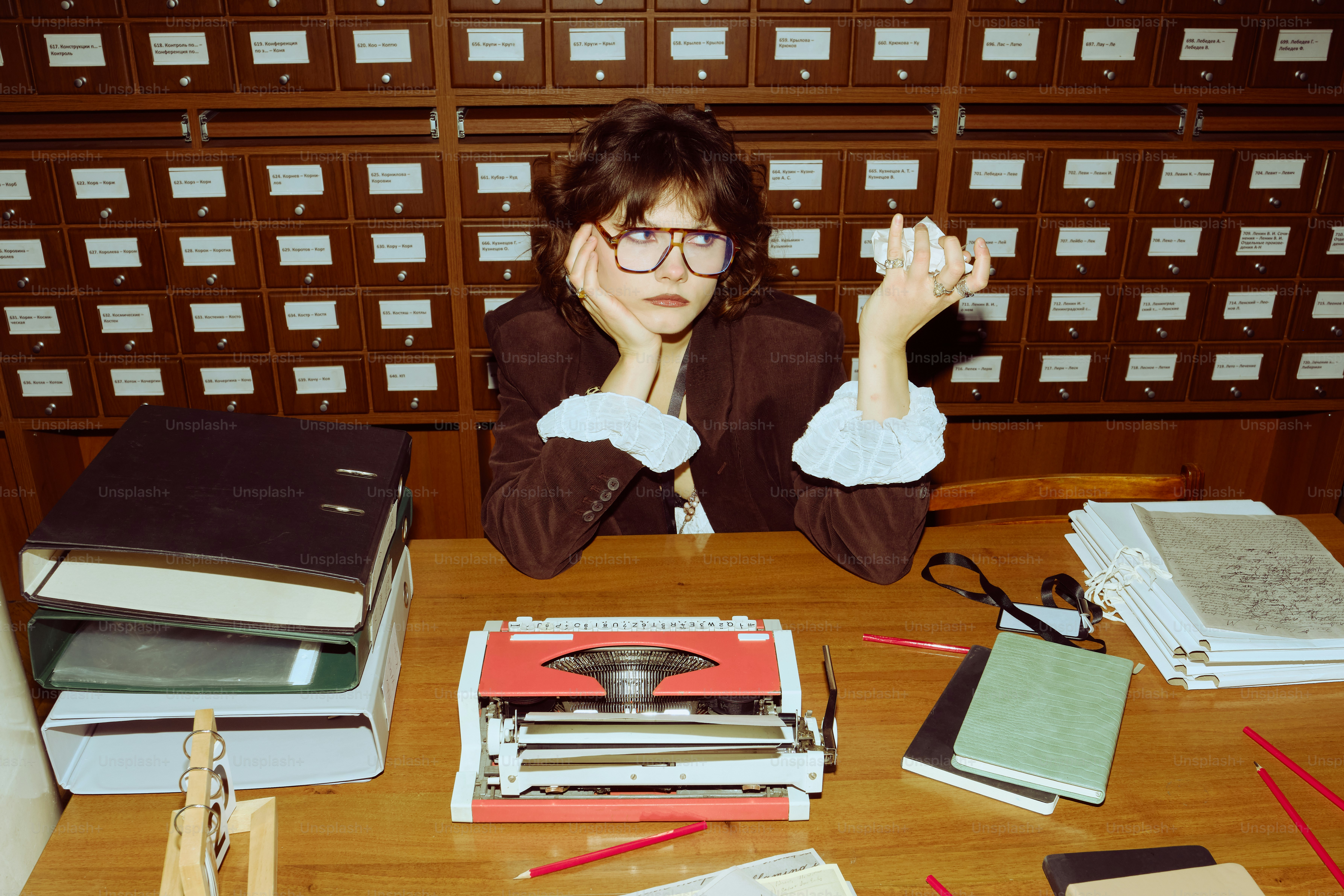 Woman with glasses at a desk with typewriter