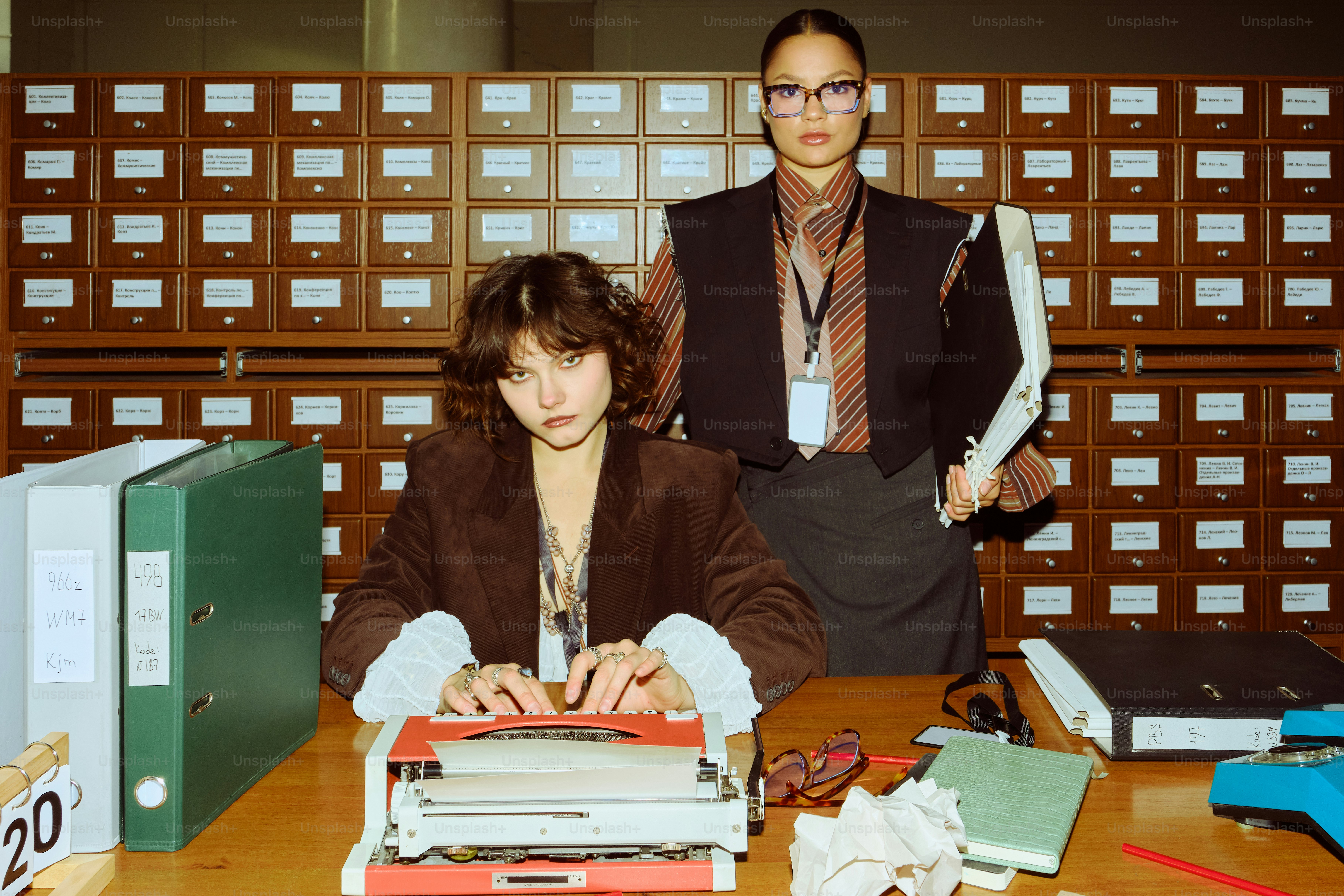 Two women at a desk with a typewriter.