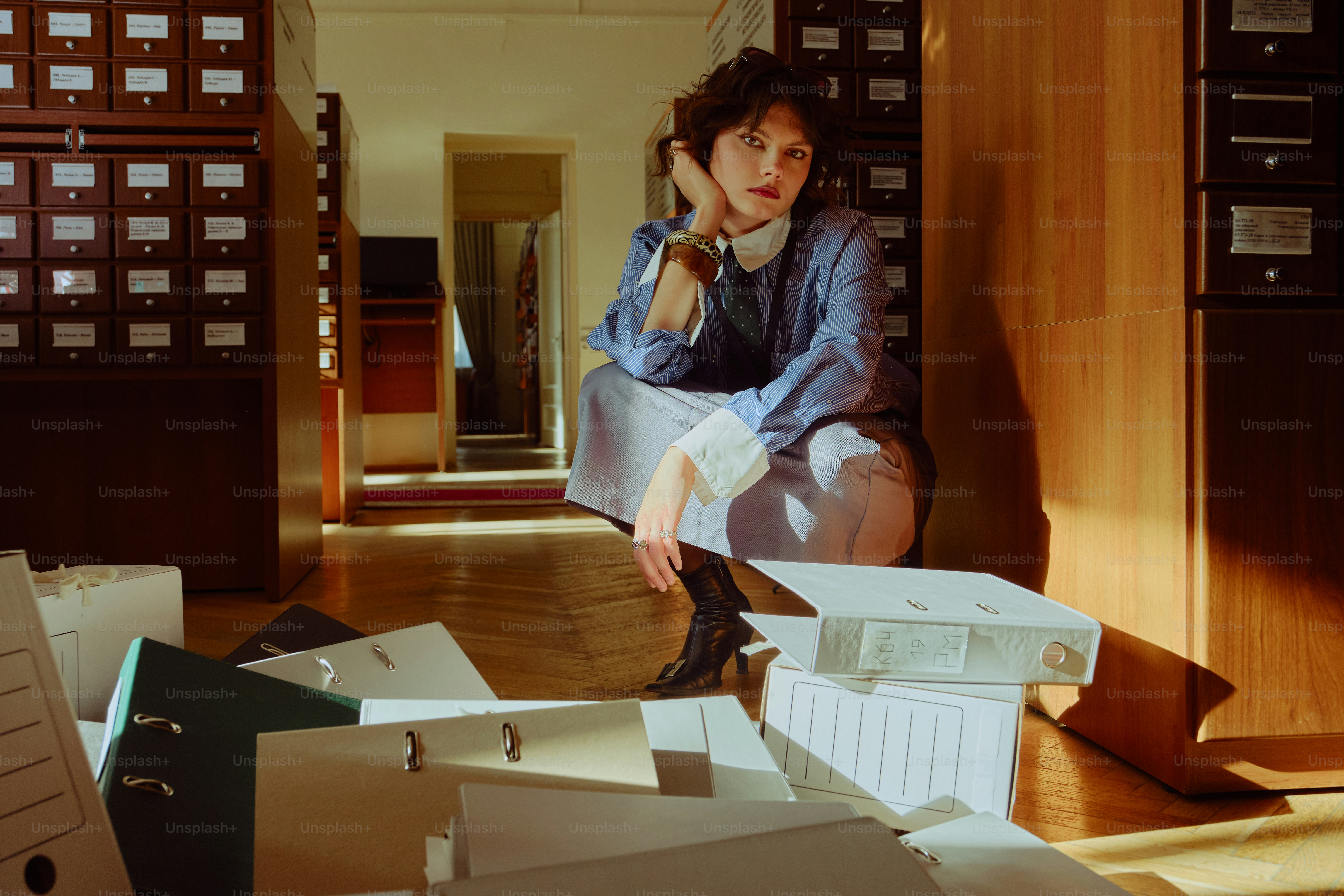 Woman in vintage clothing surrounded by files