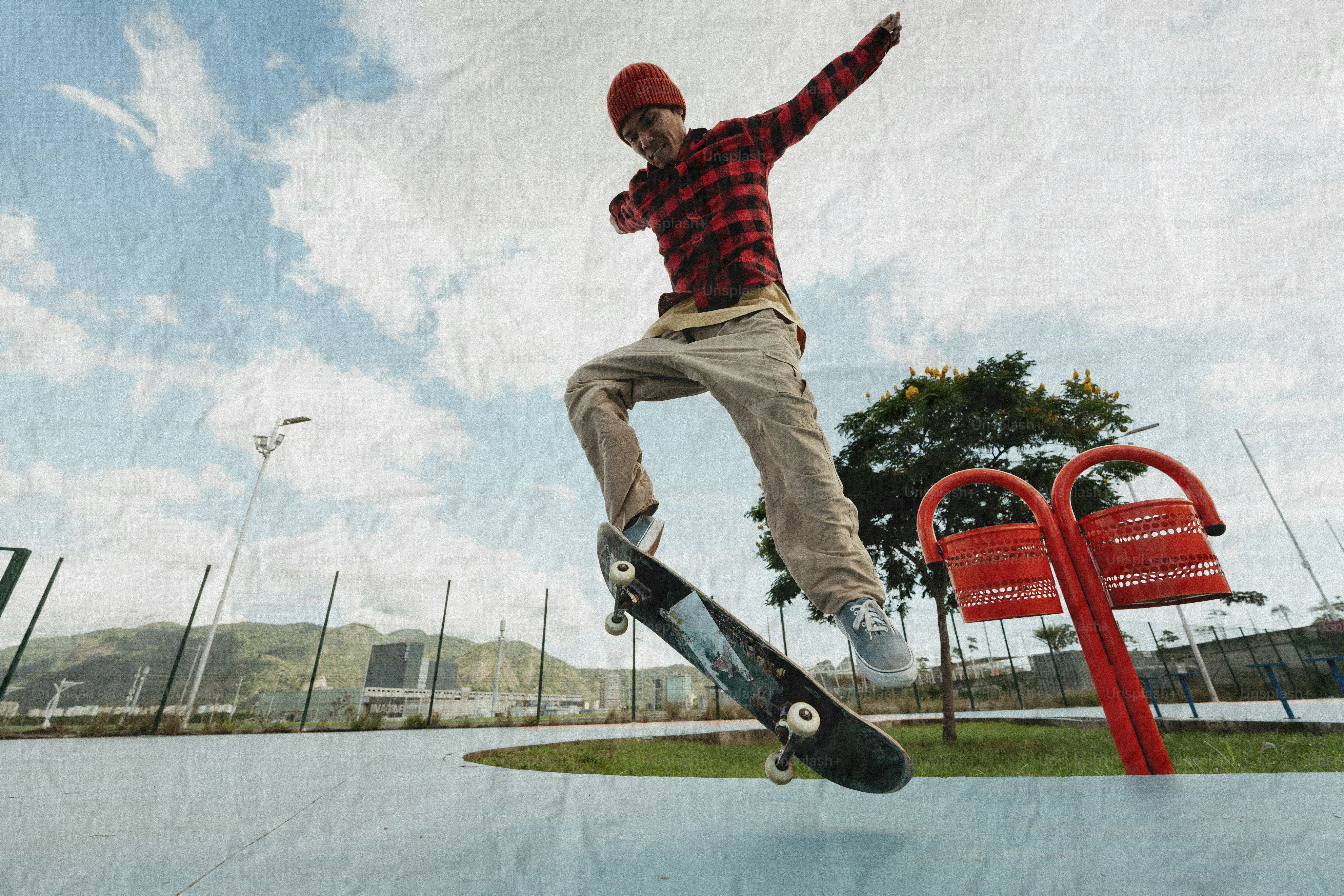 Teenager performs trick on skateboard at skatepark