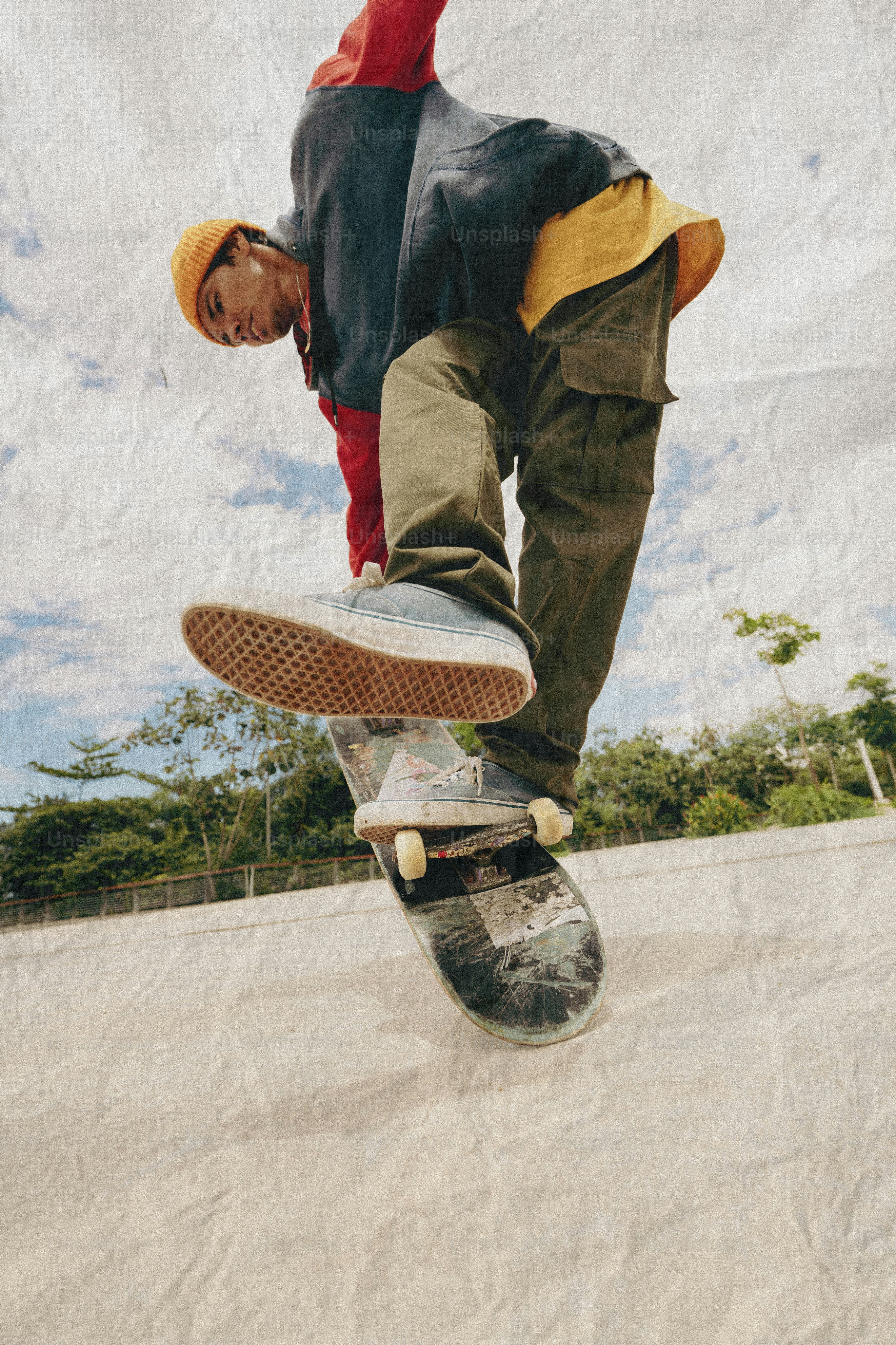 Skateboarder performing a trick outdoors on a sunny day.