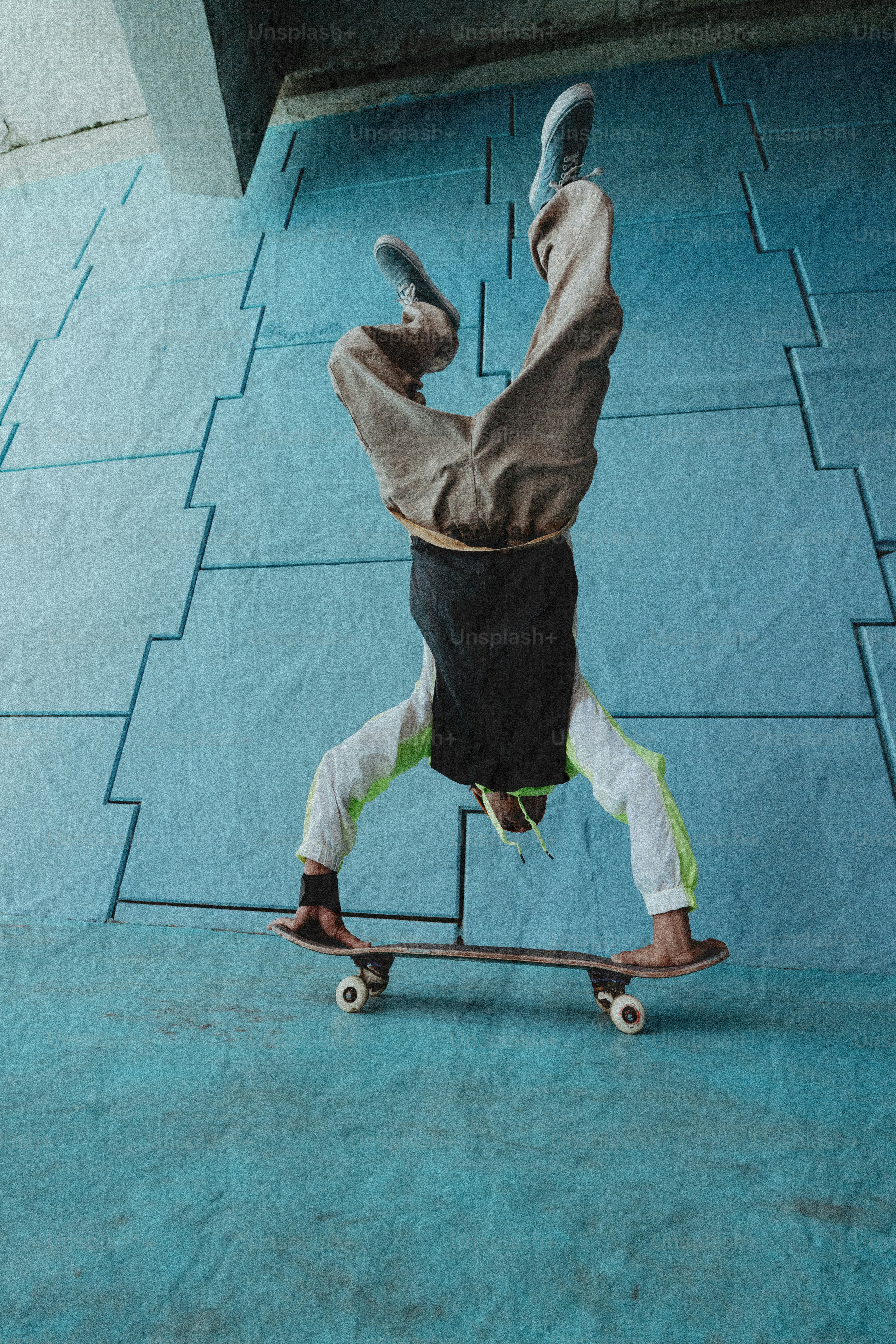 Person doing a handstand on a skateboard.