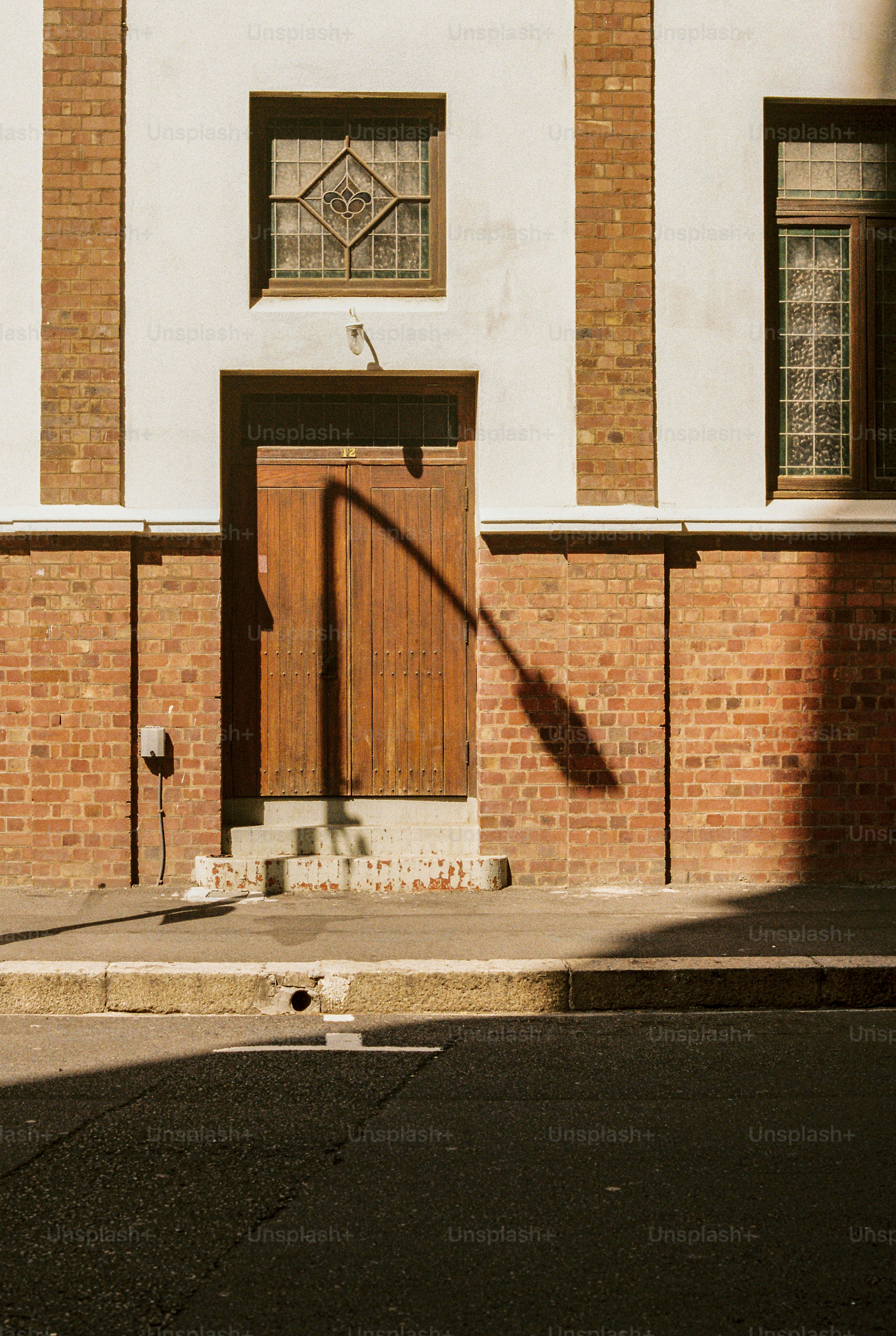 La puerta de madera proyecta una sombra sobre la fachada del edificio de ladrillo