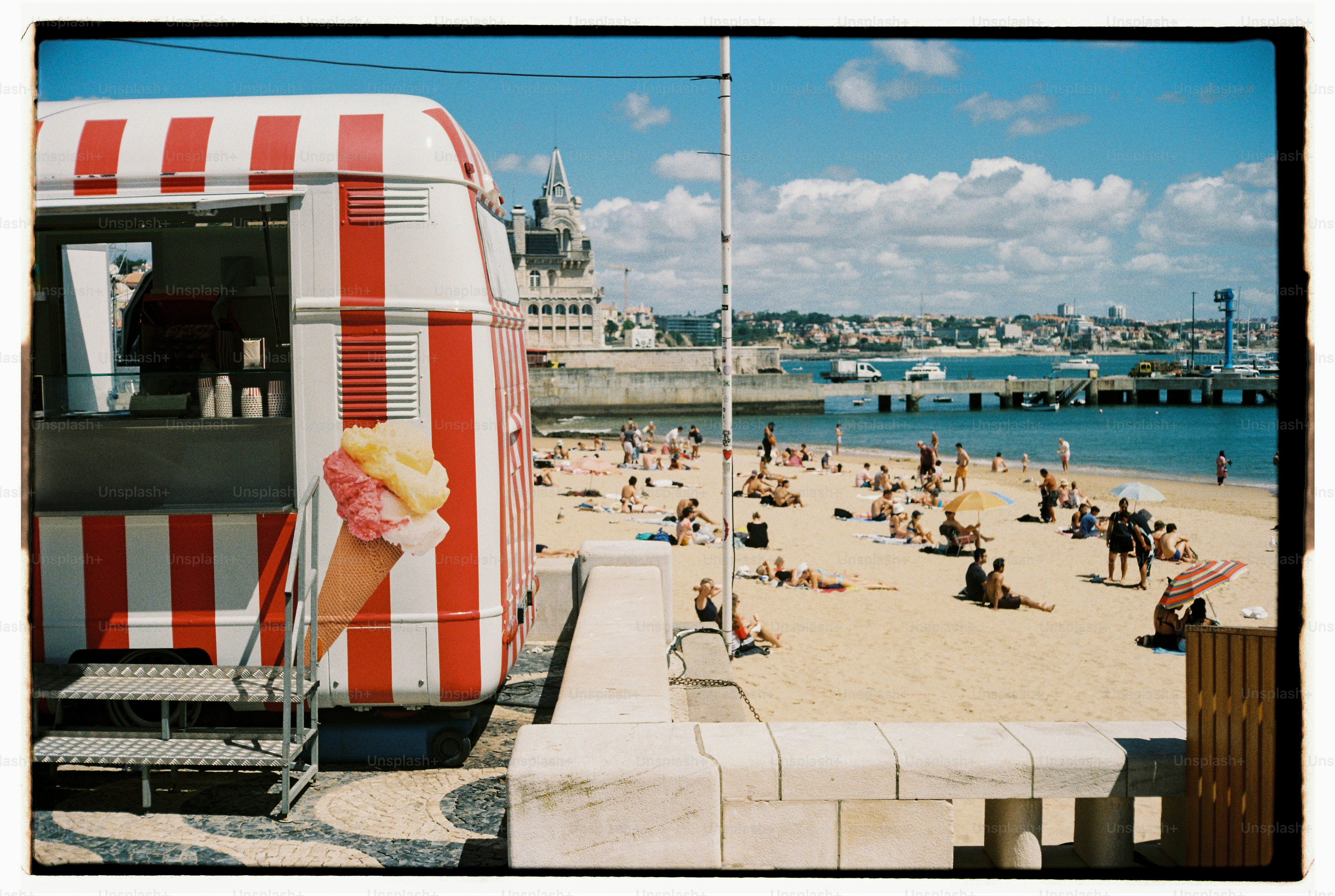 Stand de glaces sur une plage ensoleillée avec beaucoup de monde.