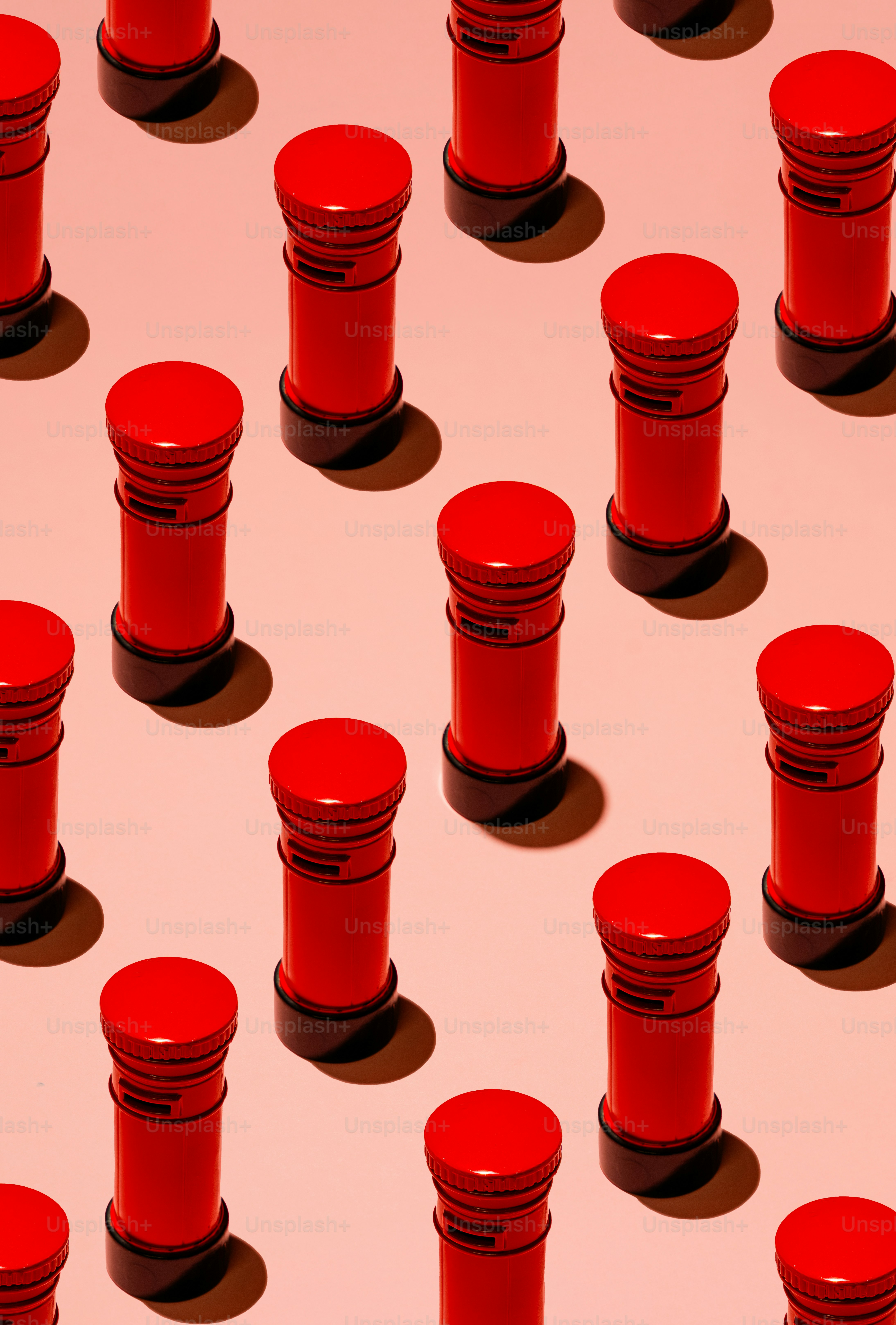 Pattern of red cylindrical objects on pink background