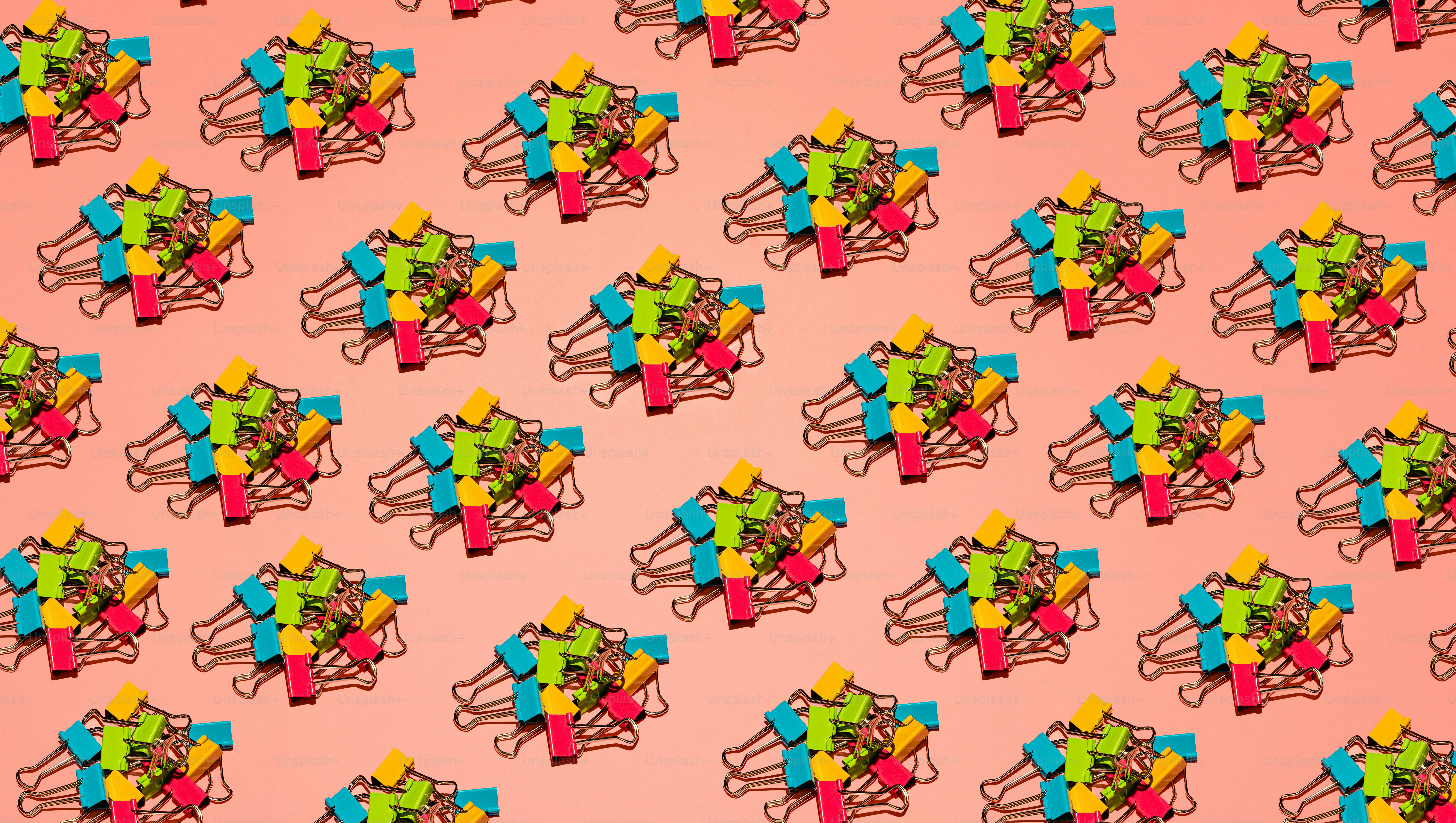 Colorful binder clips arranged in a repeating pattern