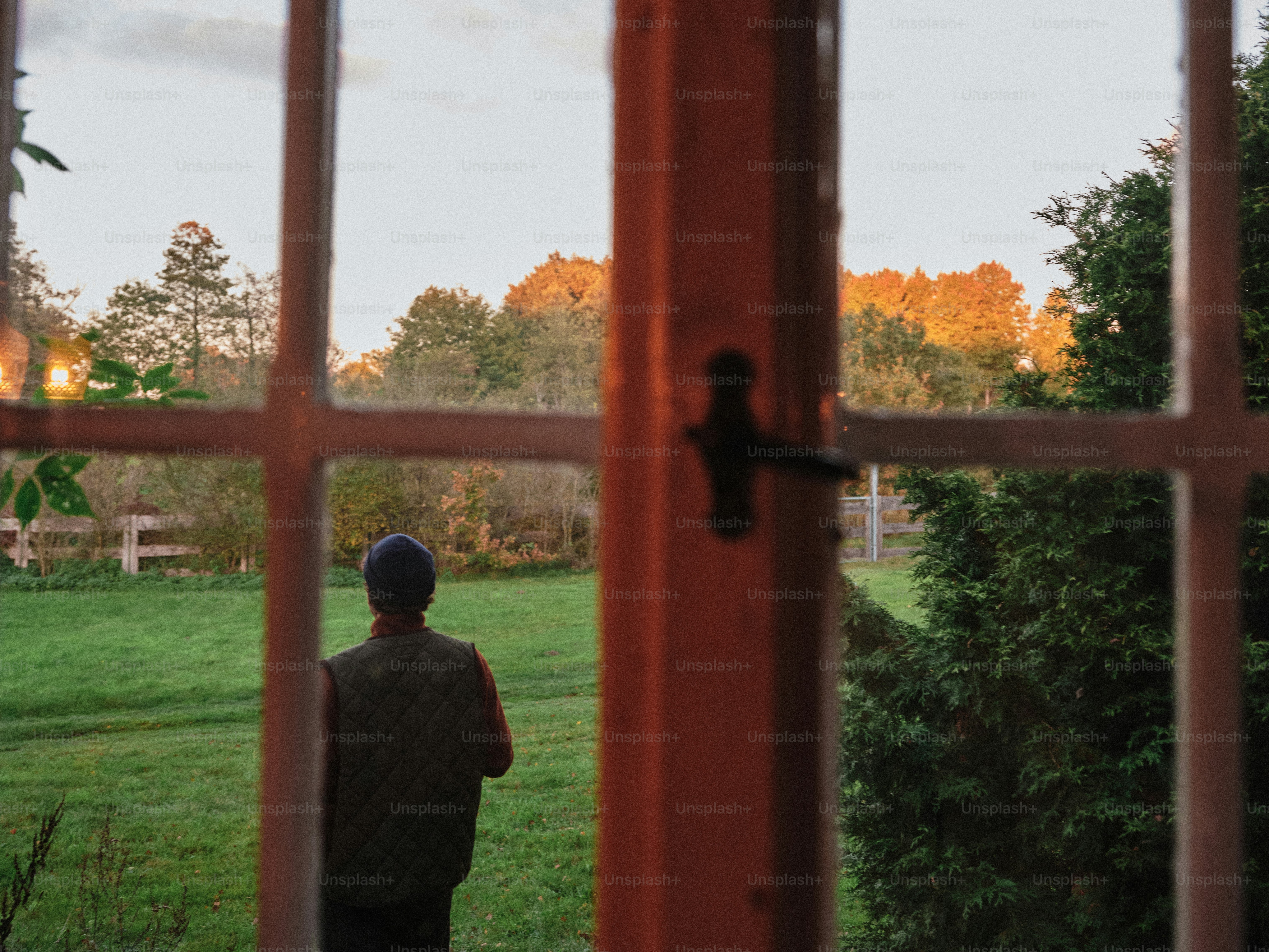 夕暮れ時に窓の外を眺める人