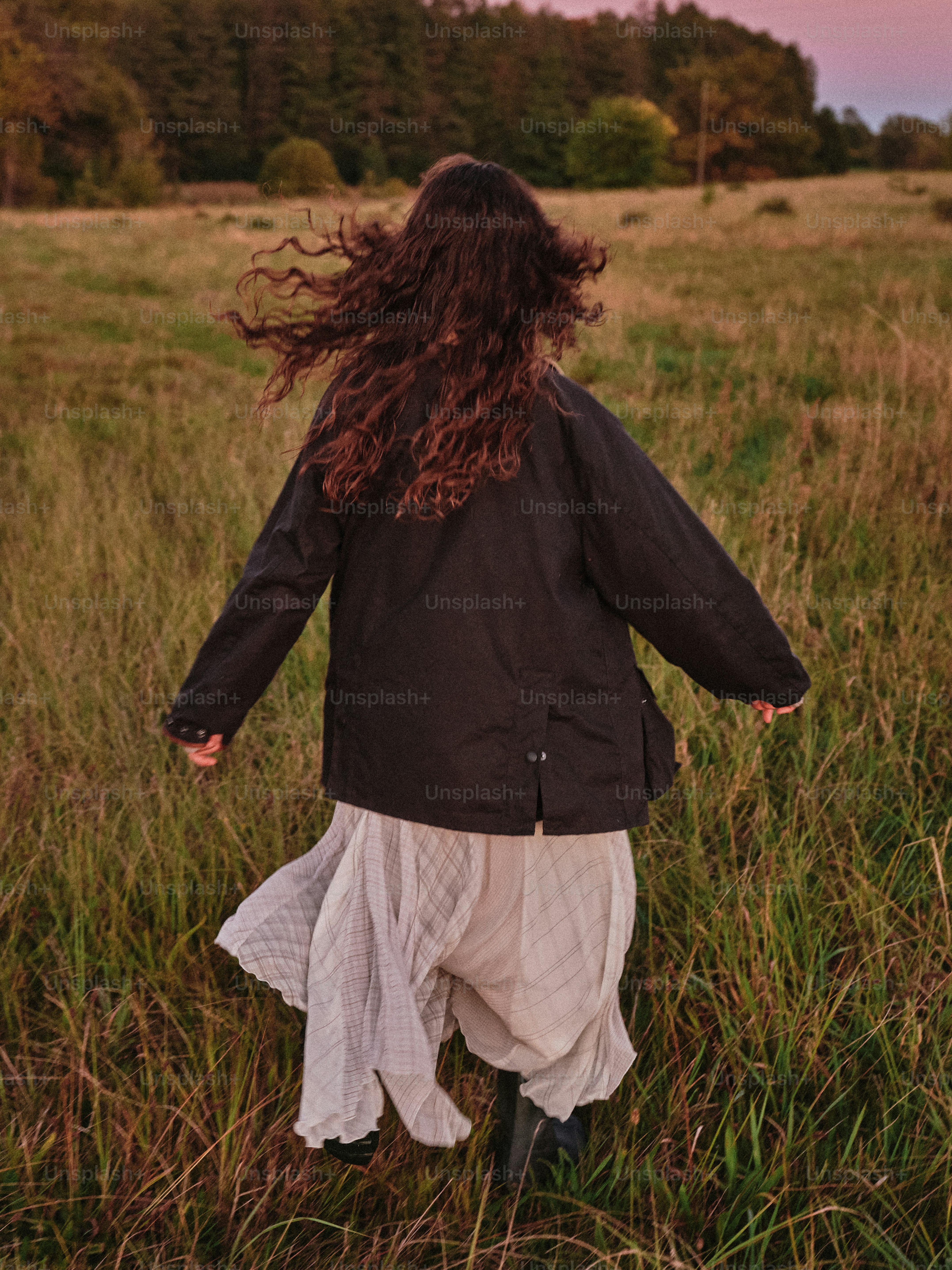 草原を駆け抜ける長い髪の女性。
