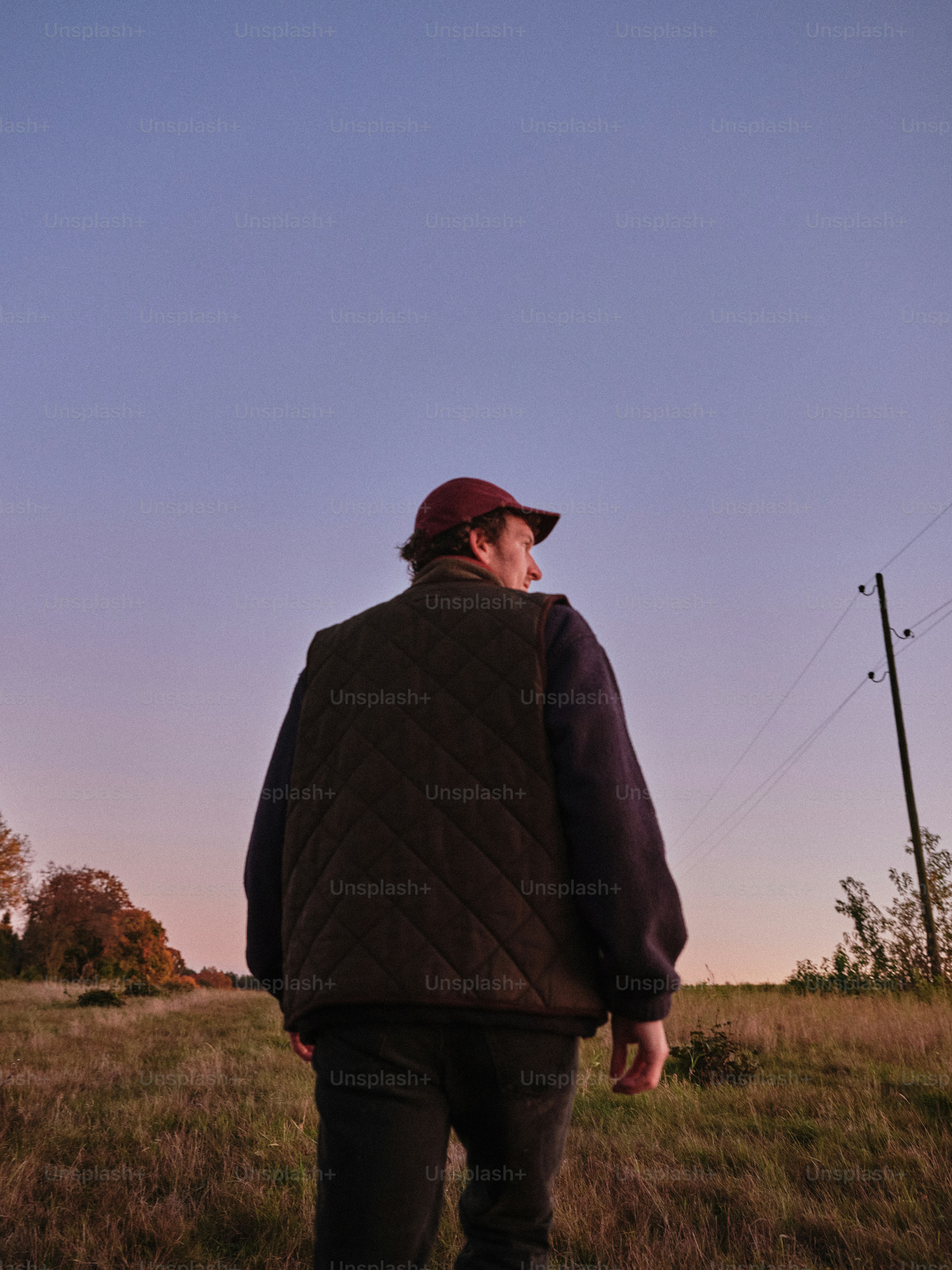 野原でベストと野球帽をかぶった男性