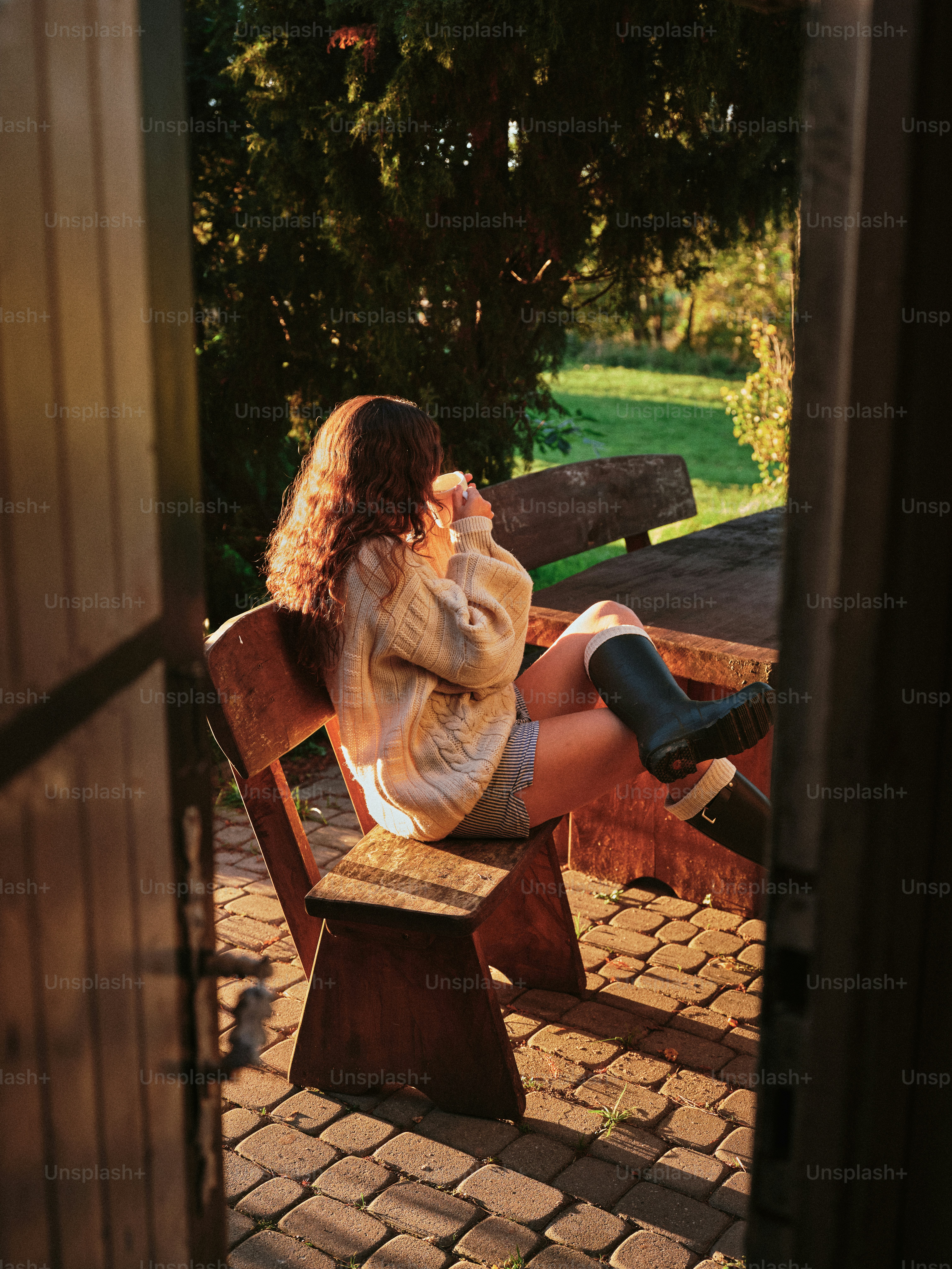 屋外でコーヒーを飲みながら椅子に座っている女性。