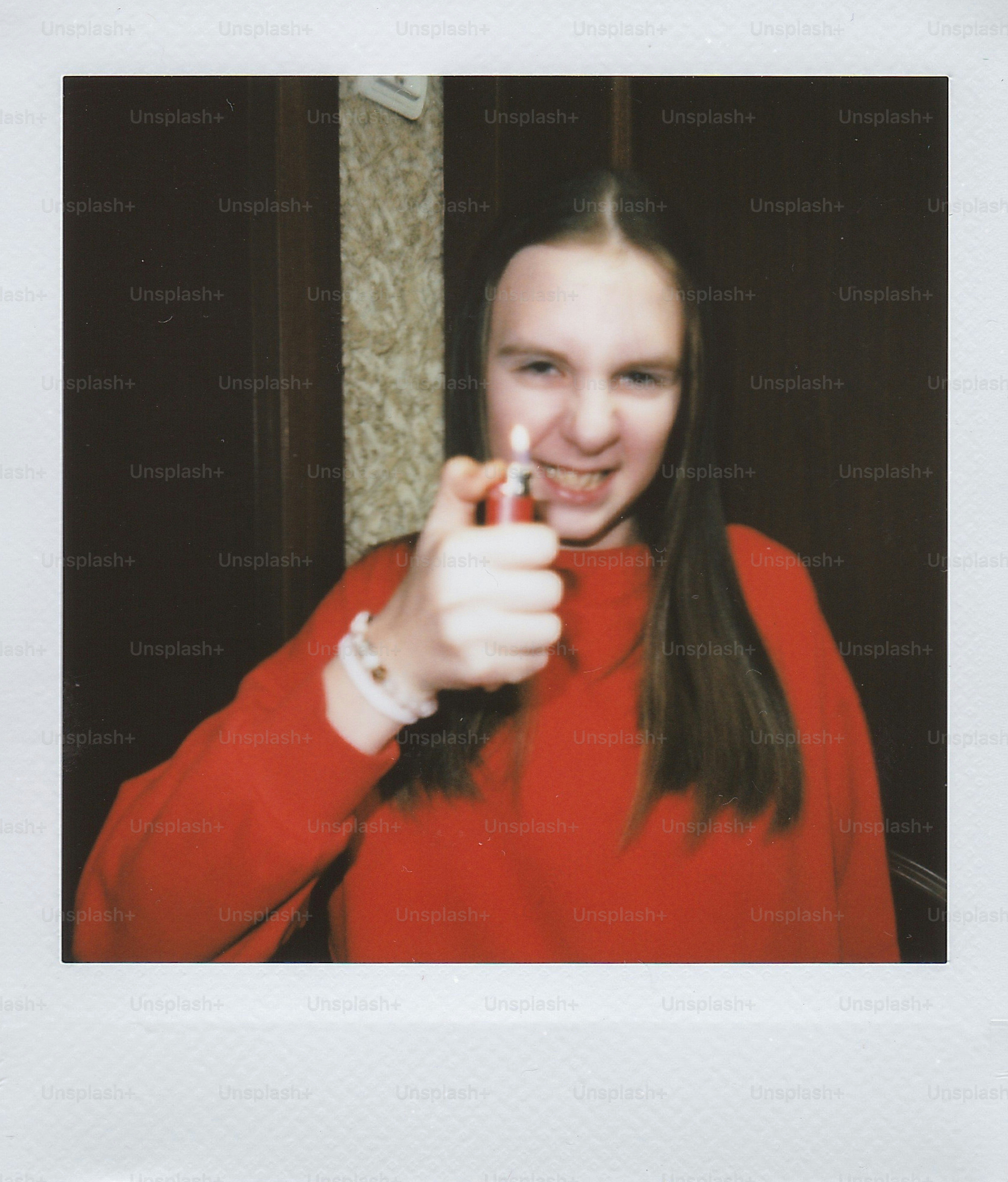 Jeune femme en chemise rouge tenant un briquet.