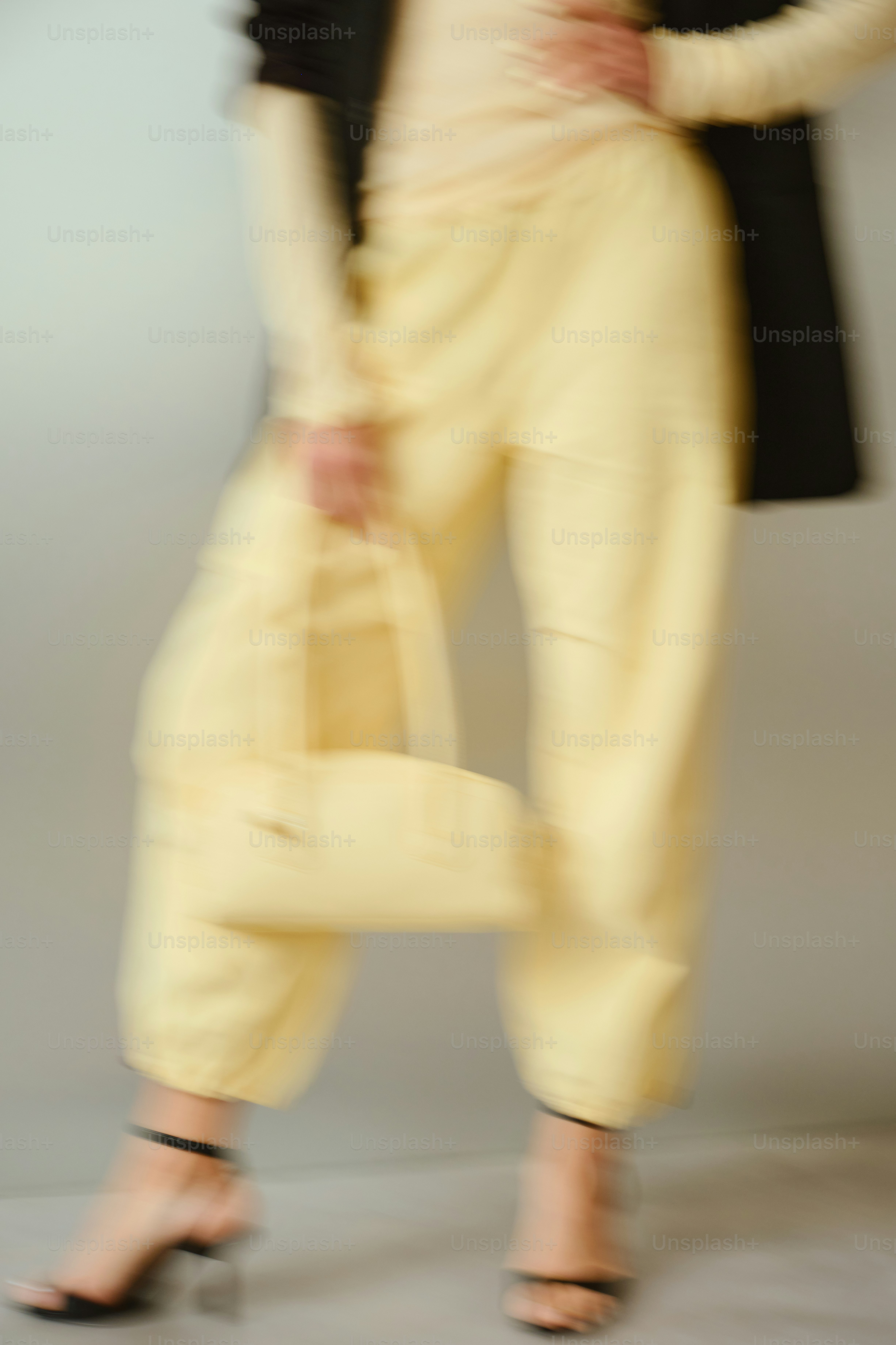 Woman in light yellow outfit holding a handbag
