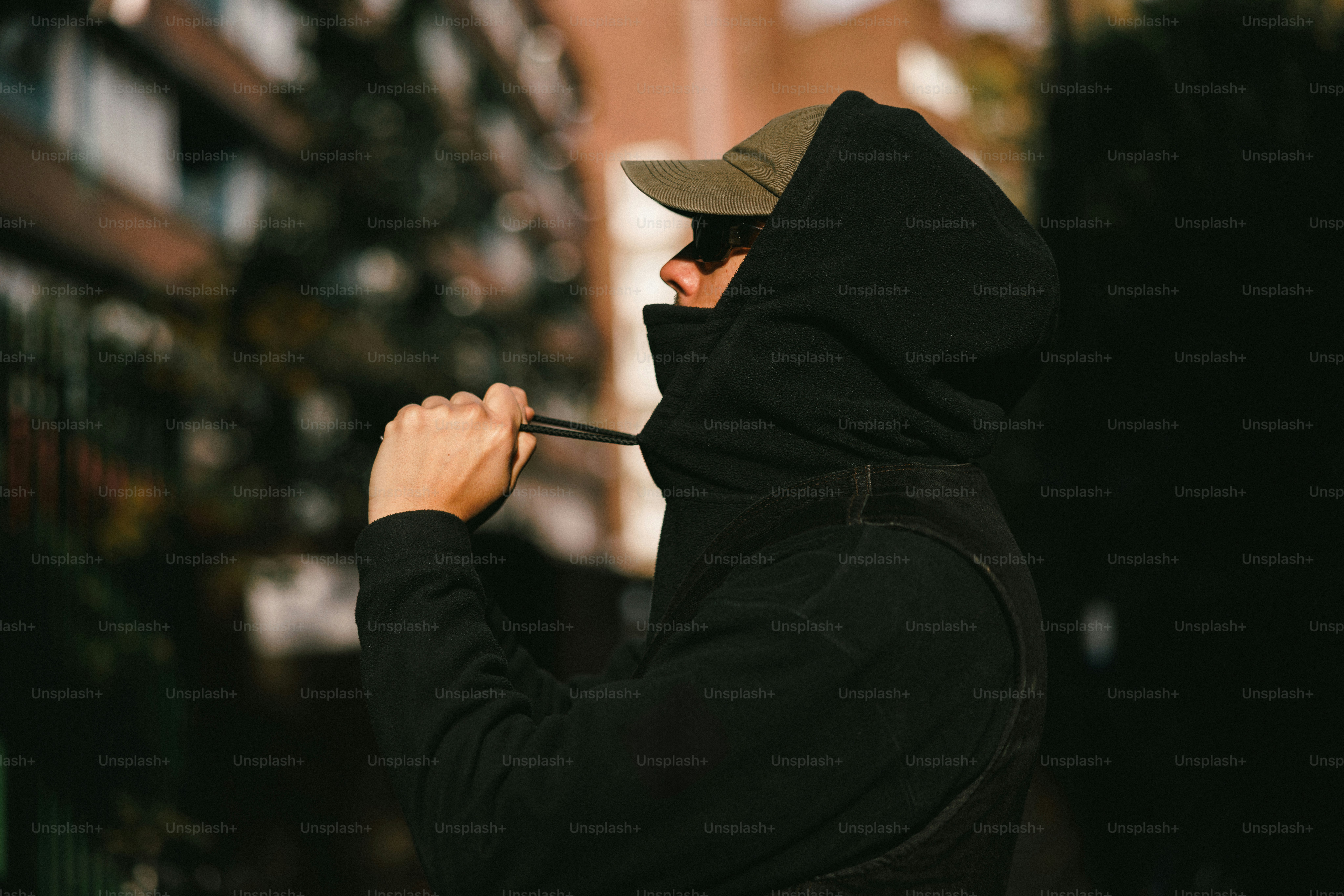 Homem com capuz preto puxa cordão apertado