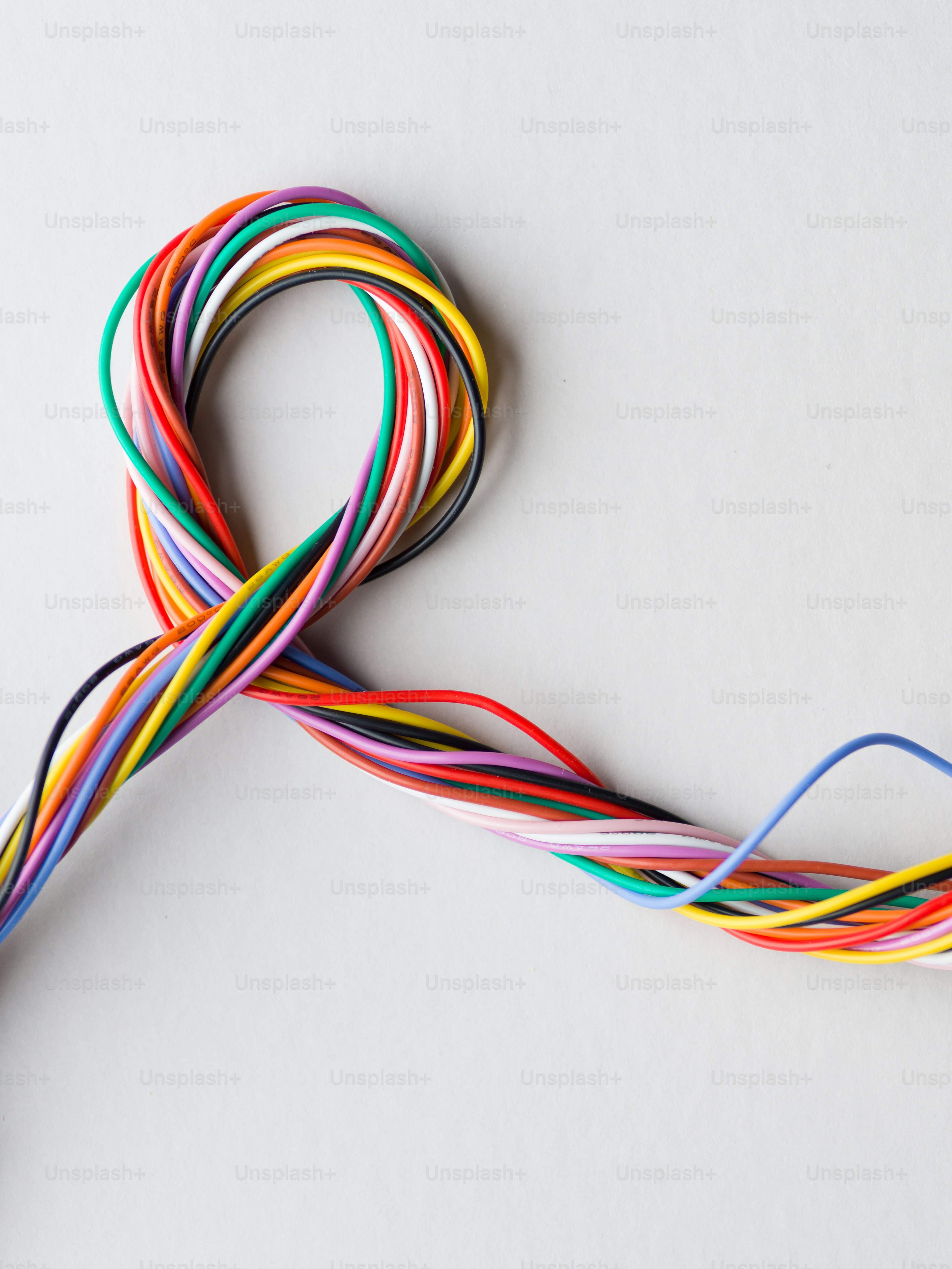 흰색 배경에 함께 꼬인 다채로운 전선 묶음