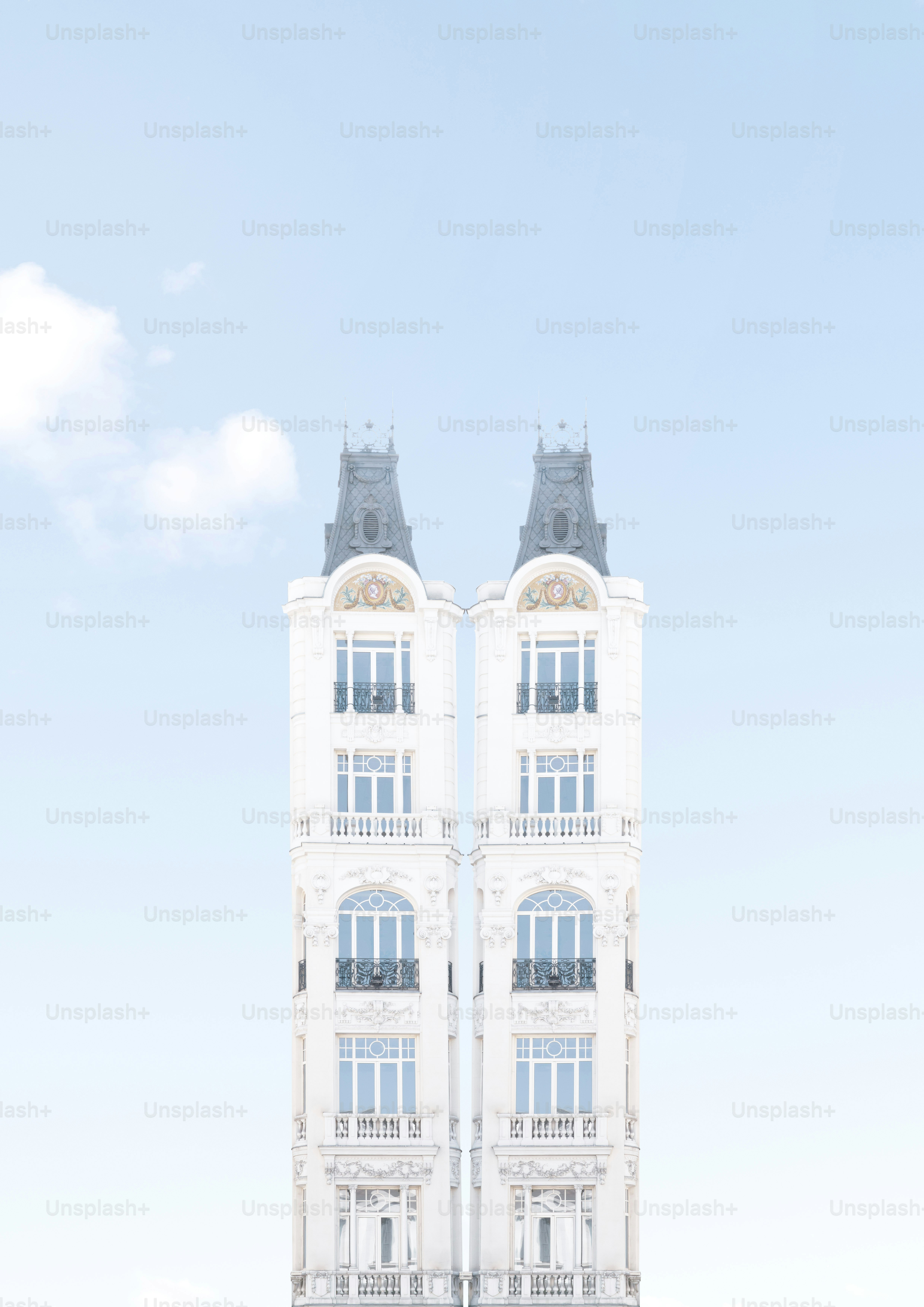 Due edifici bianchi simmetrici contro un cielo blu.