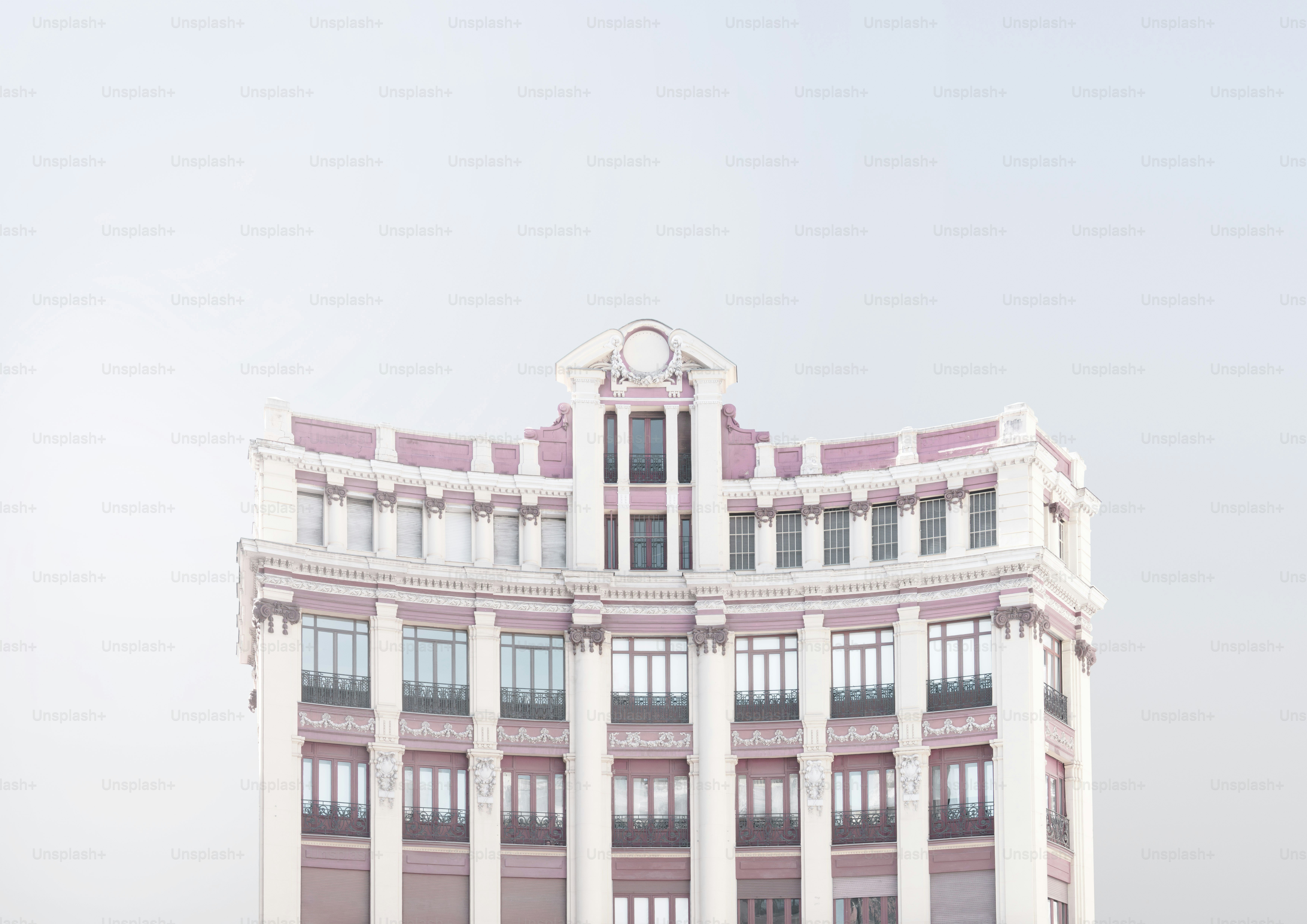Facciata dell'edificio decorata con accenti rosa contro il cielo.