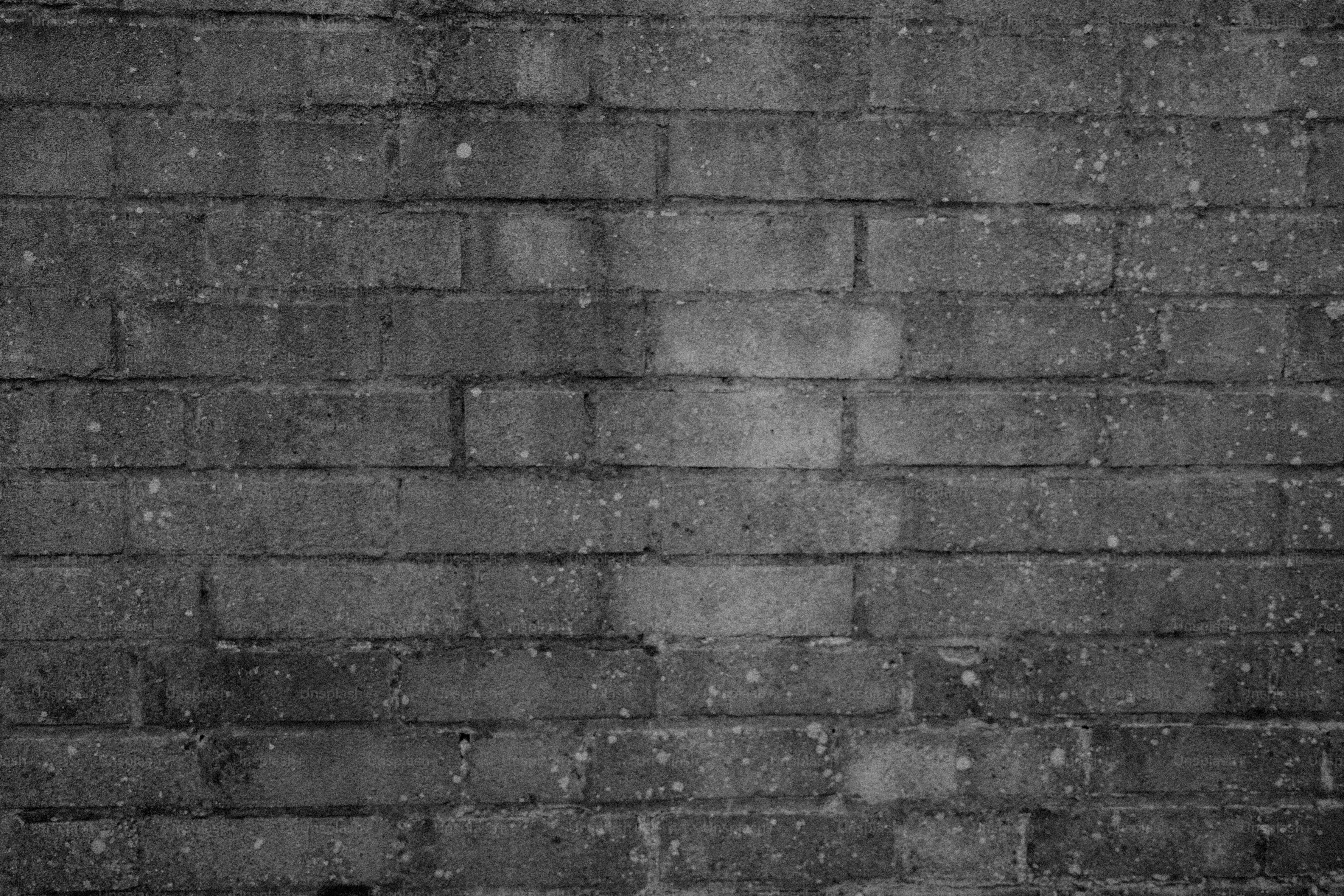 A textured gray brick wall with some discoloration.