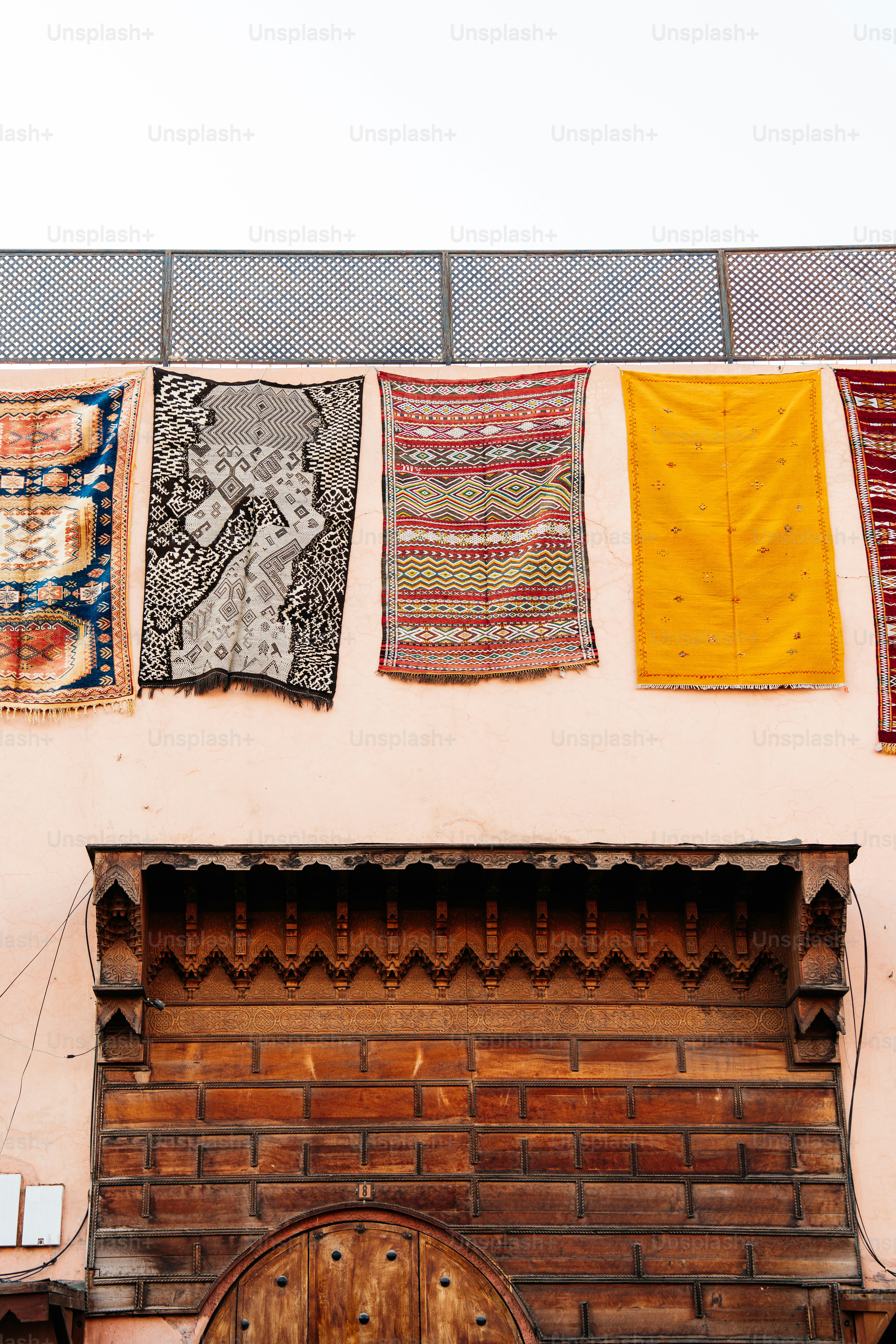 Colorful rugs hanging on a textured wall