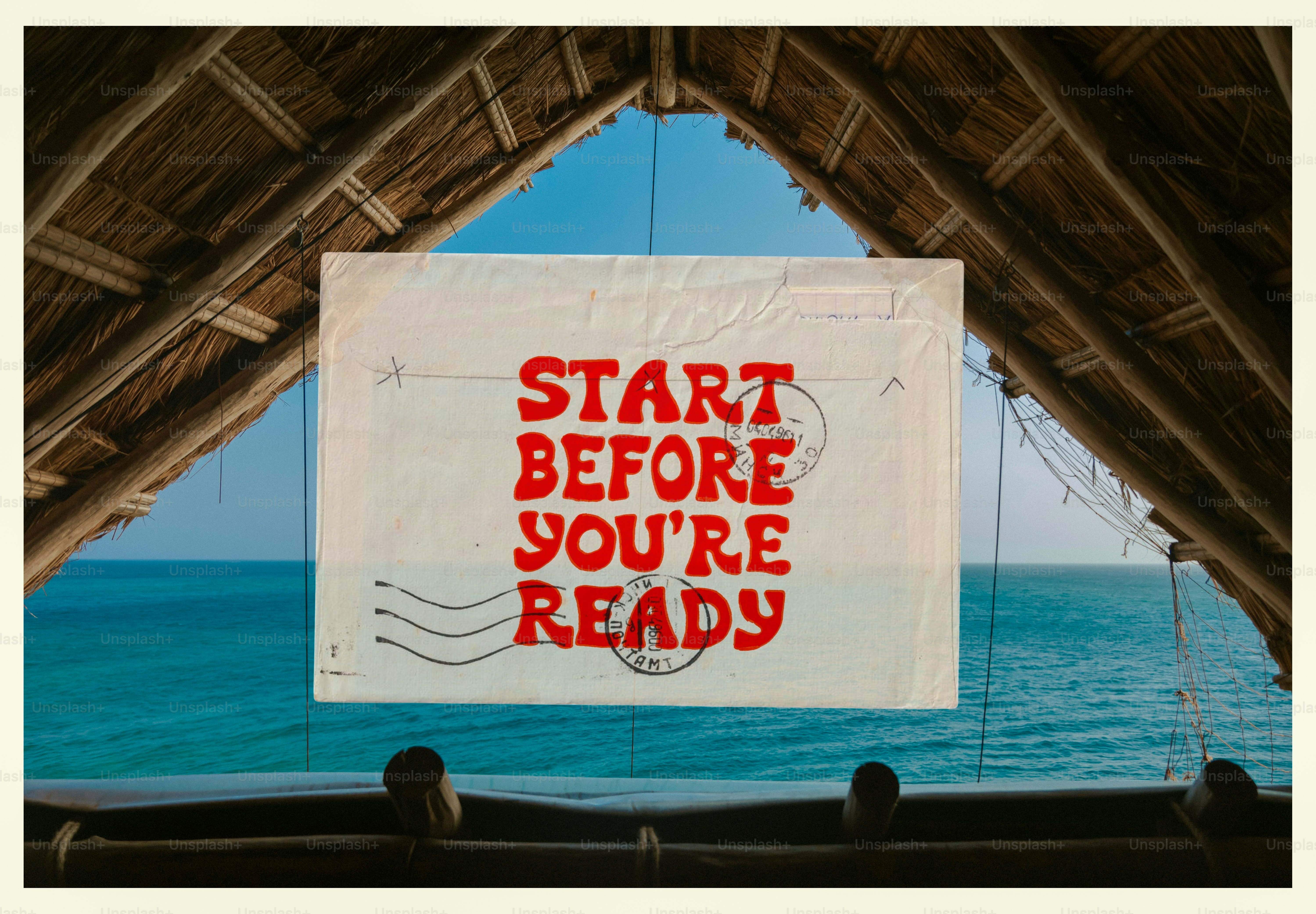 Sign with 'start before you're ready' over ocean.