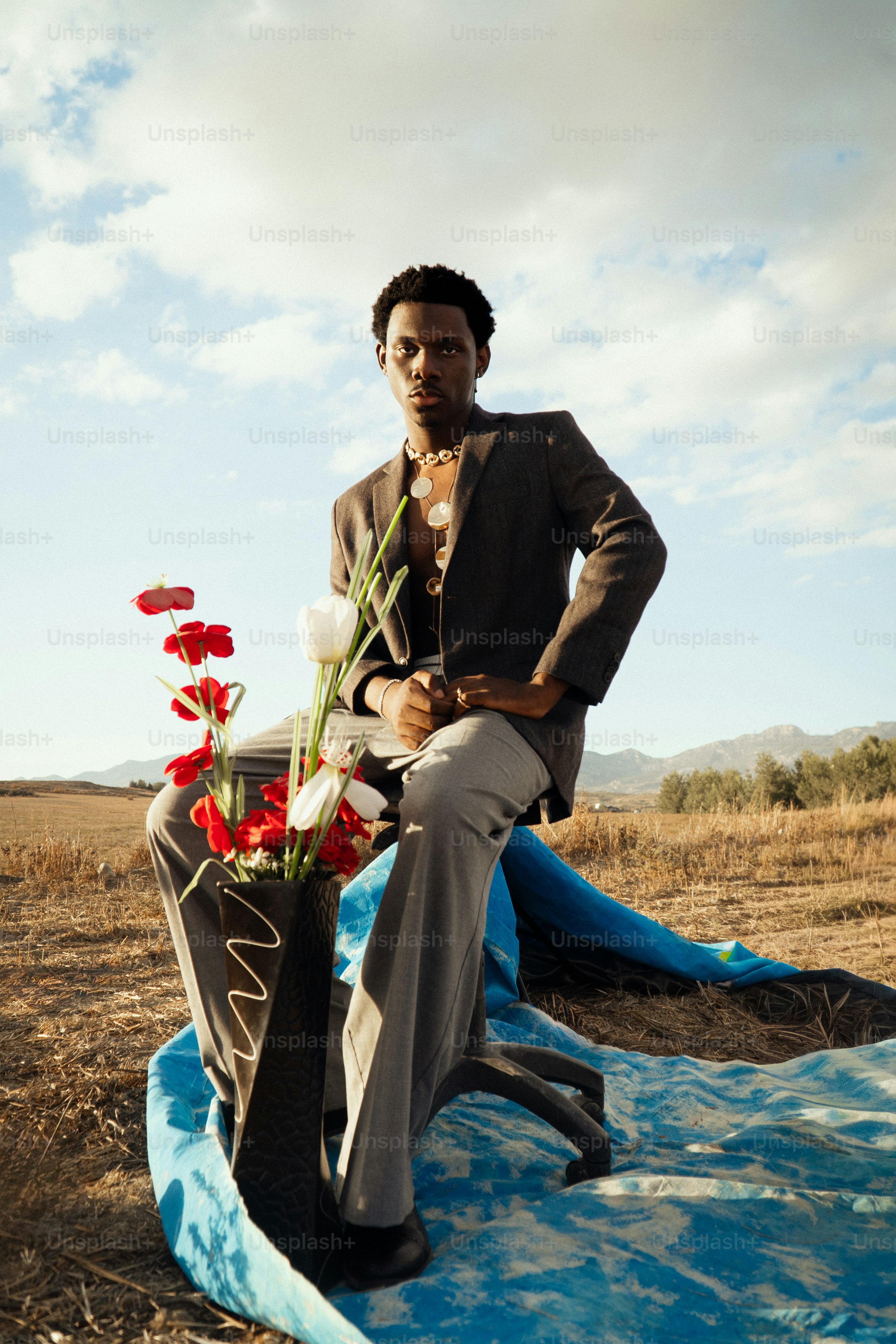 Hombre de traje sentado con flores al aire libre