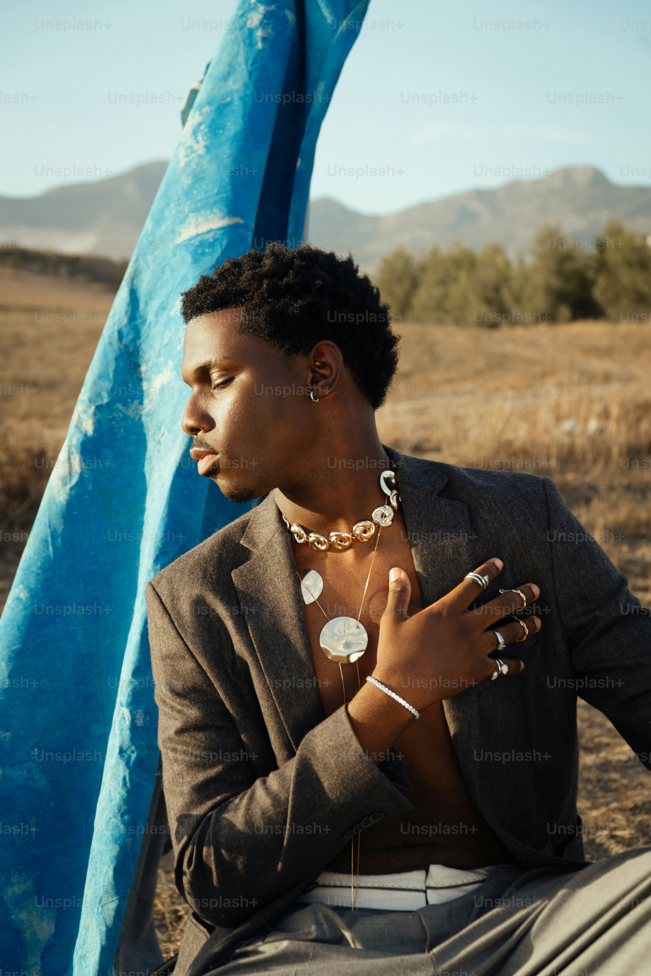 Hombre con joyas y traje al aire libre