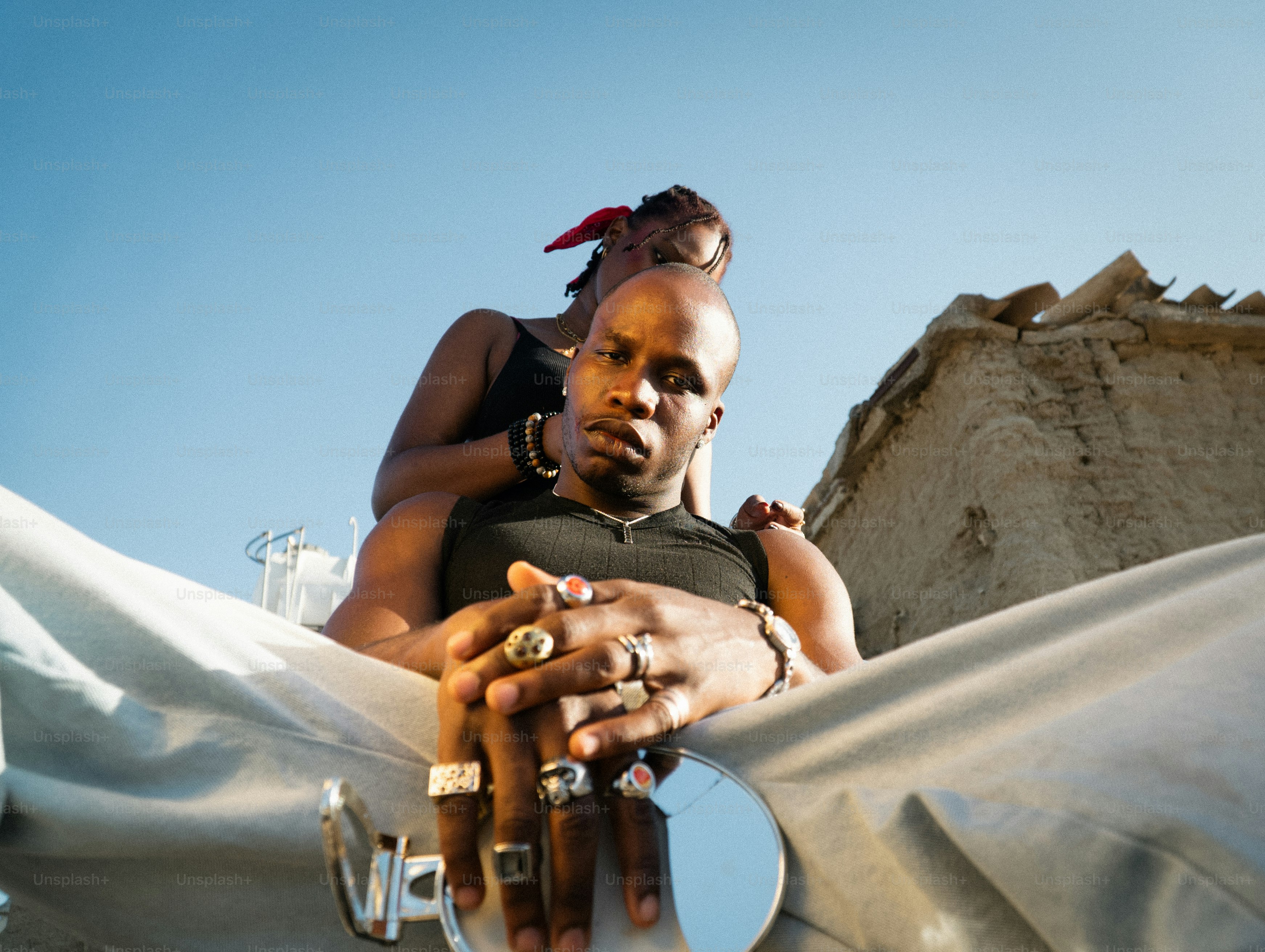 Dos personas abrazándose al aire libre con cielo despejado.