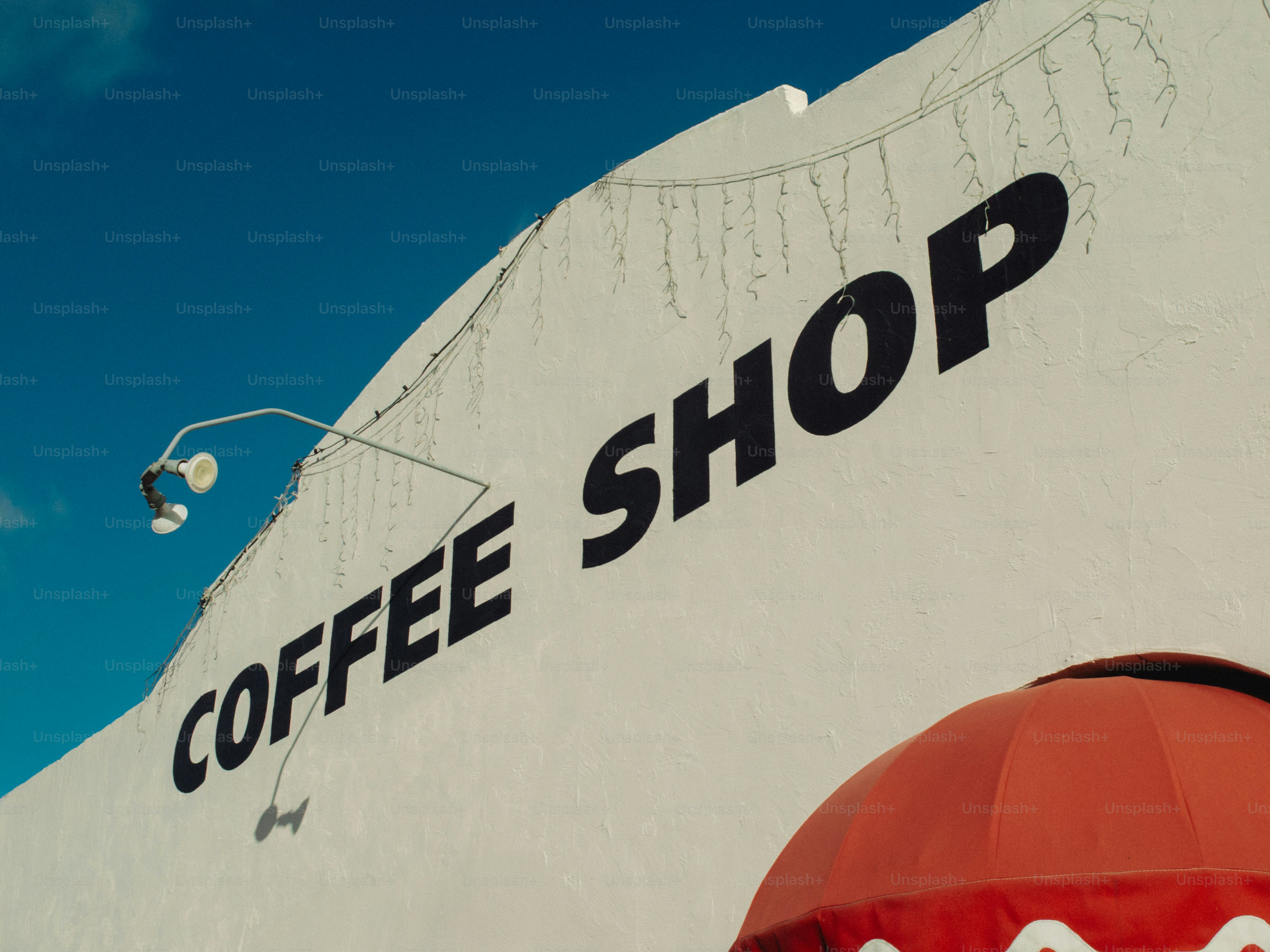 White building with "coffee shop" sign under blue sky