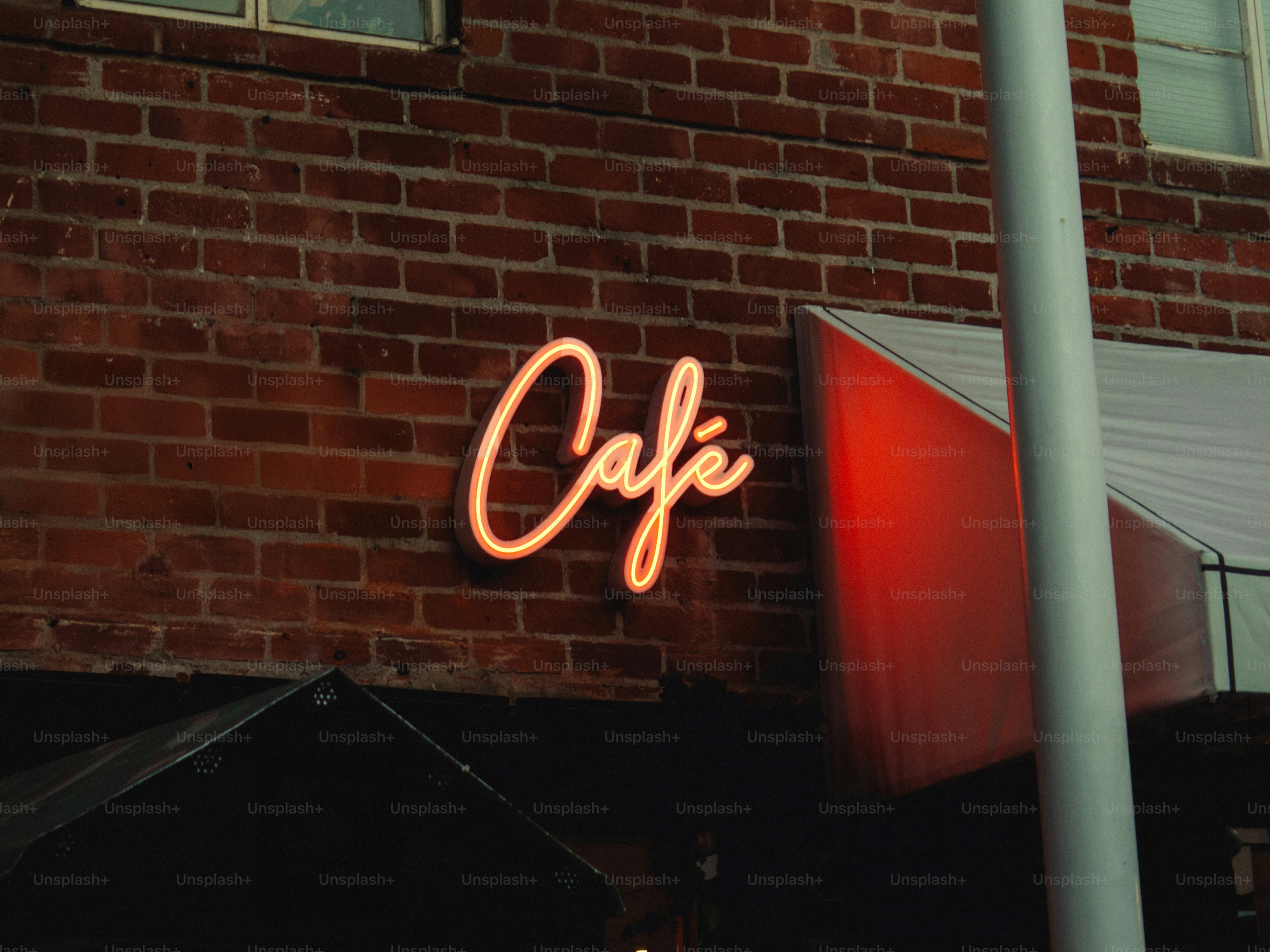 Neon-Café-Schild an Backsteinwand bei Nacht