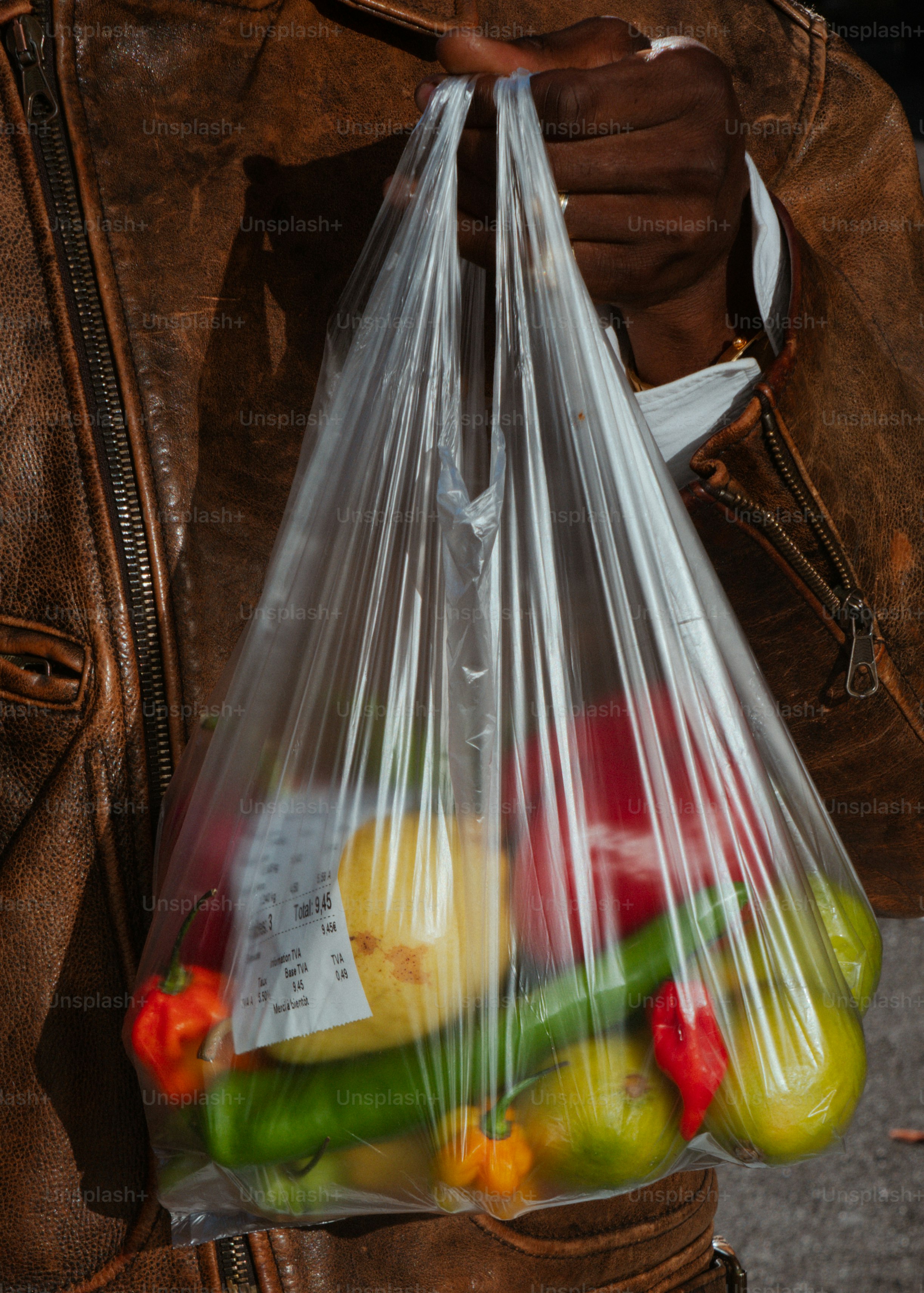 Person holding plastic bag filled with fresh produce
