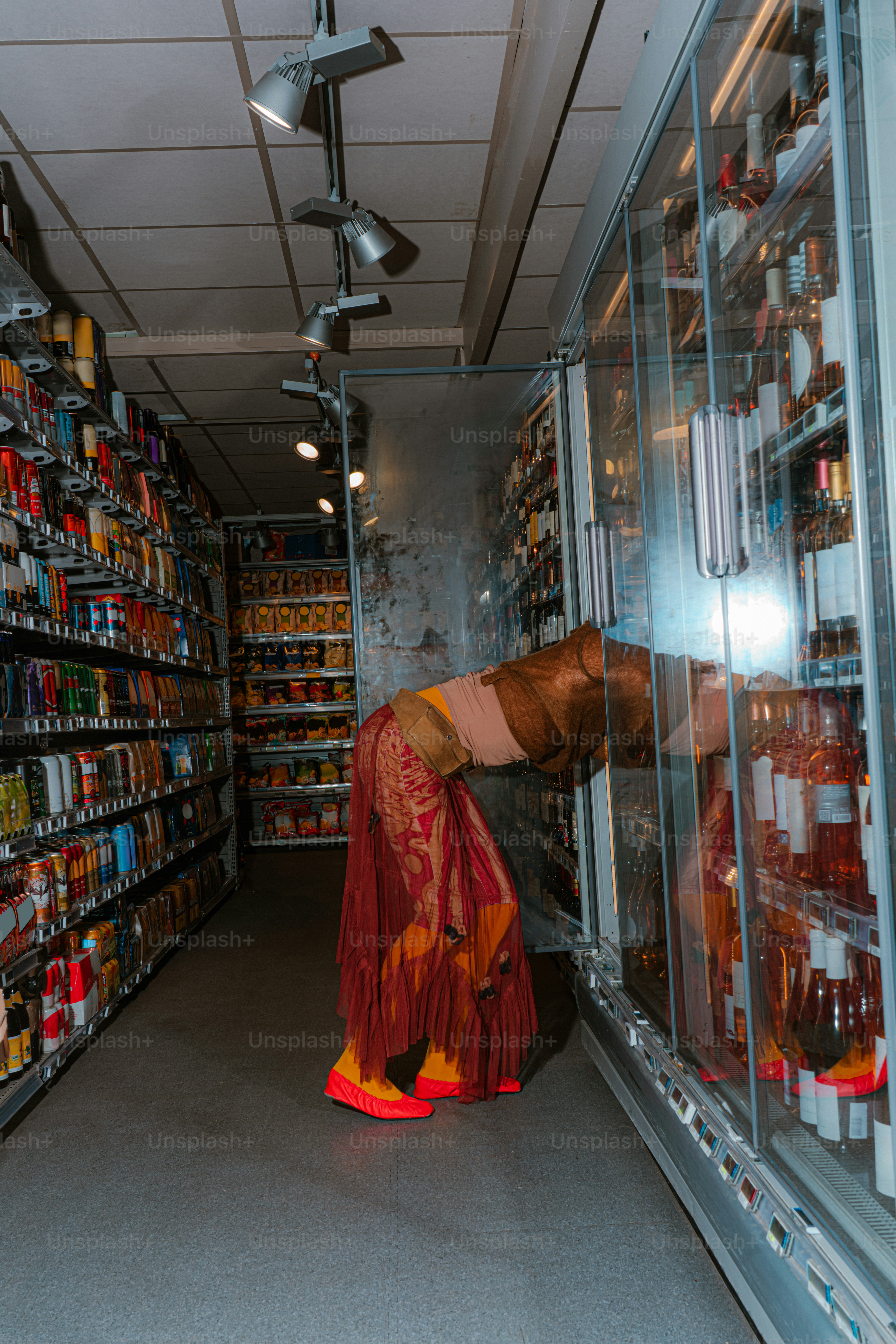 Woman bends over in a grocery store aisle.