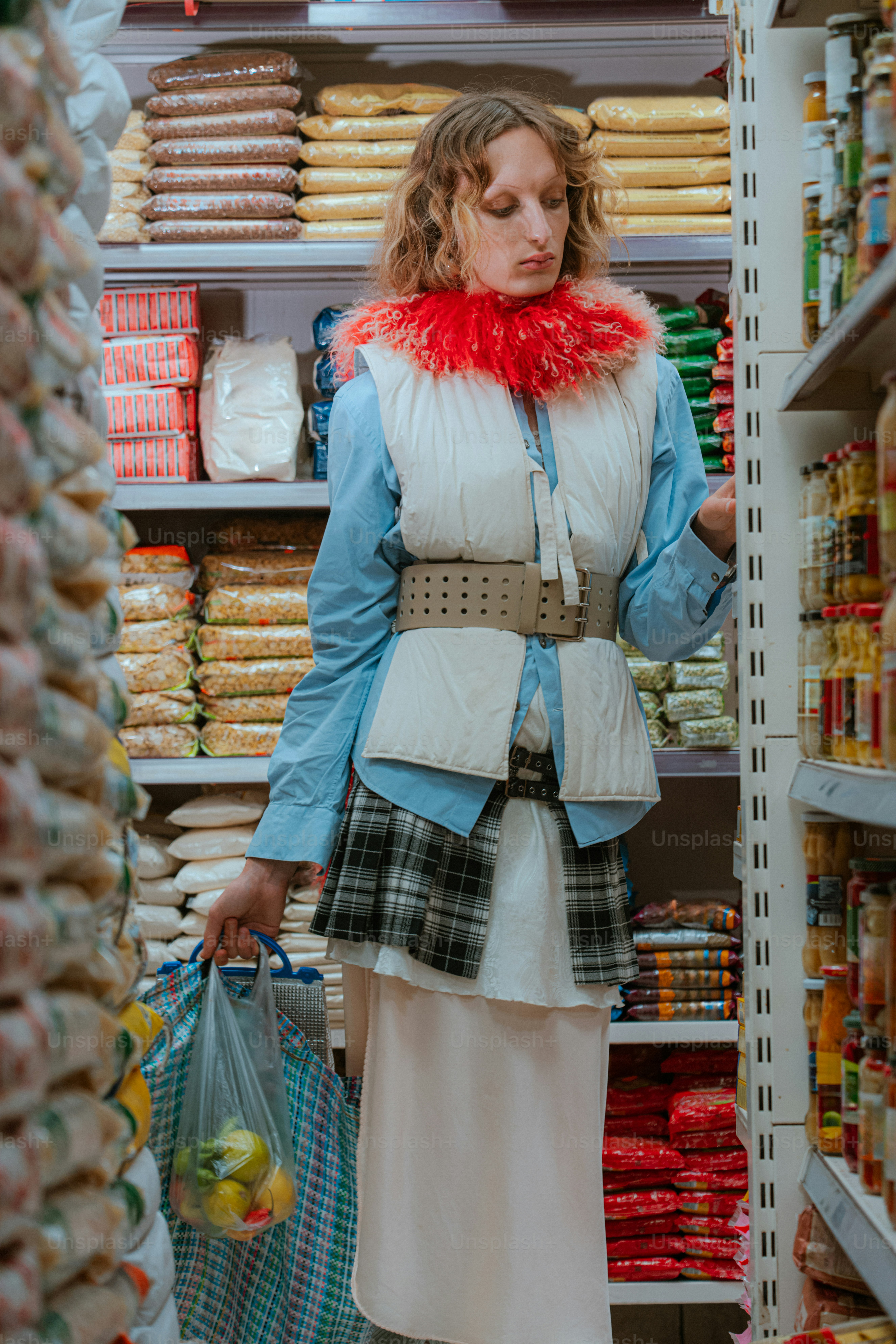 Woman shopping for groceries in a supermarket aisle.
