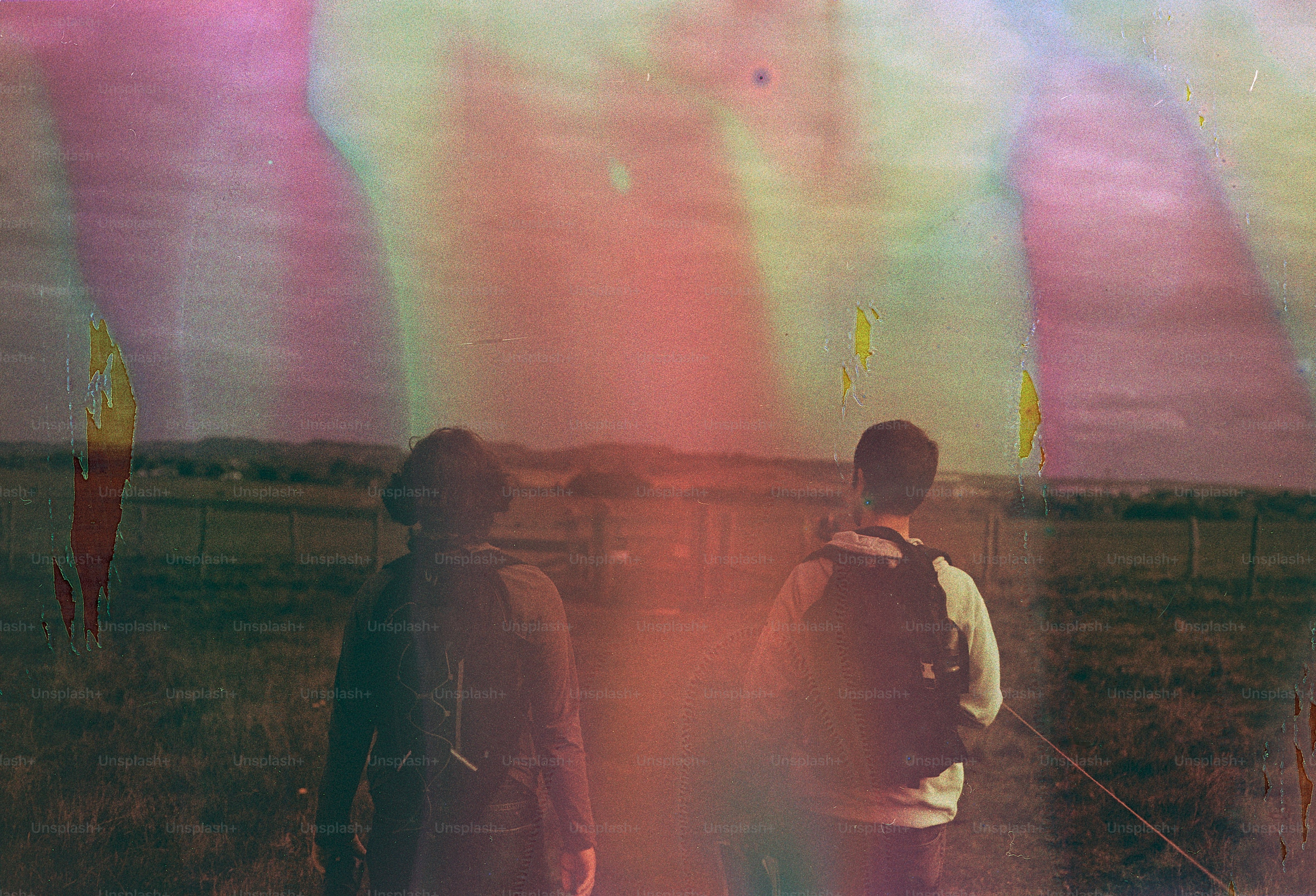 Zwei Personen laufen auf einem Weg mit bunten Lichtstreifen.