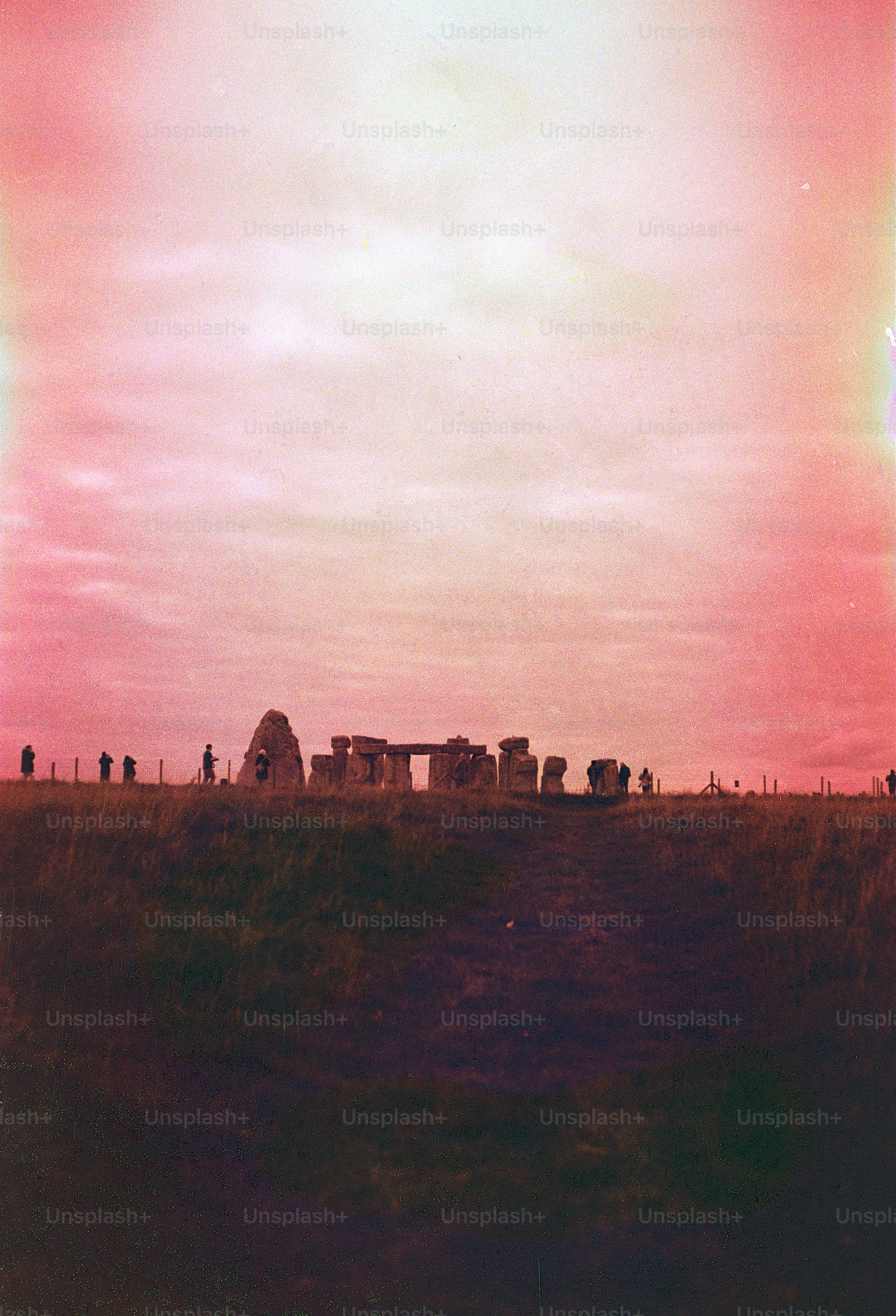 Stonehenge ancient monument under a pink sky.