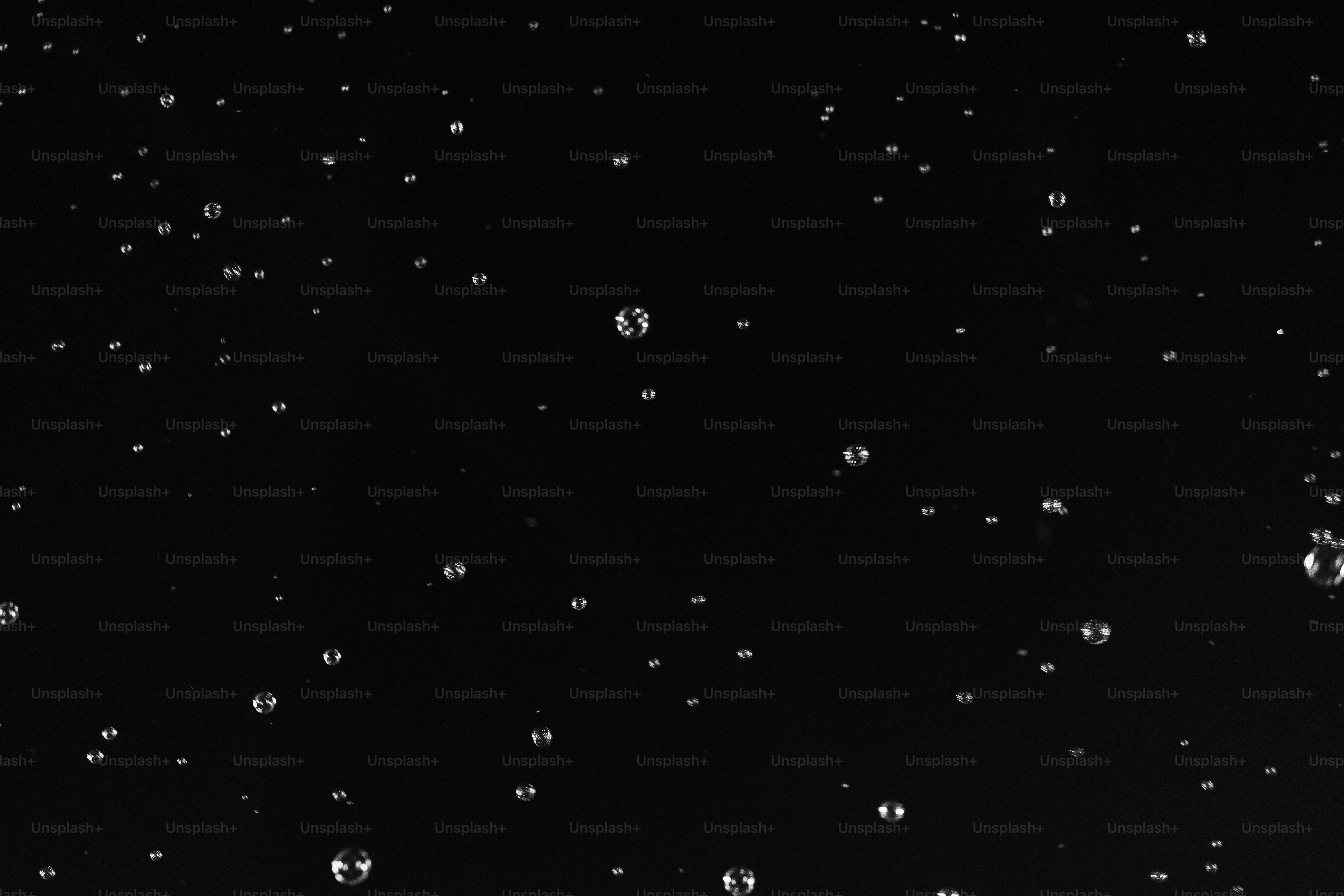 Petites gouttelettes d’eau éparpillées sur une surface noire