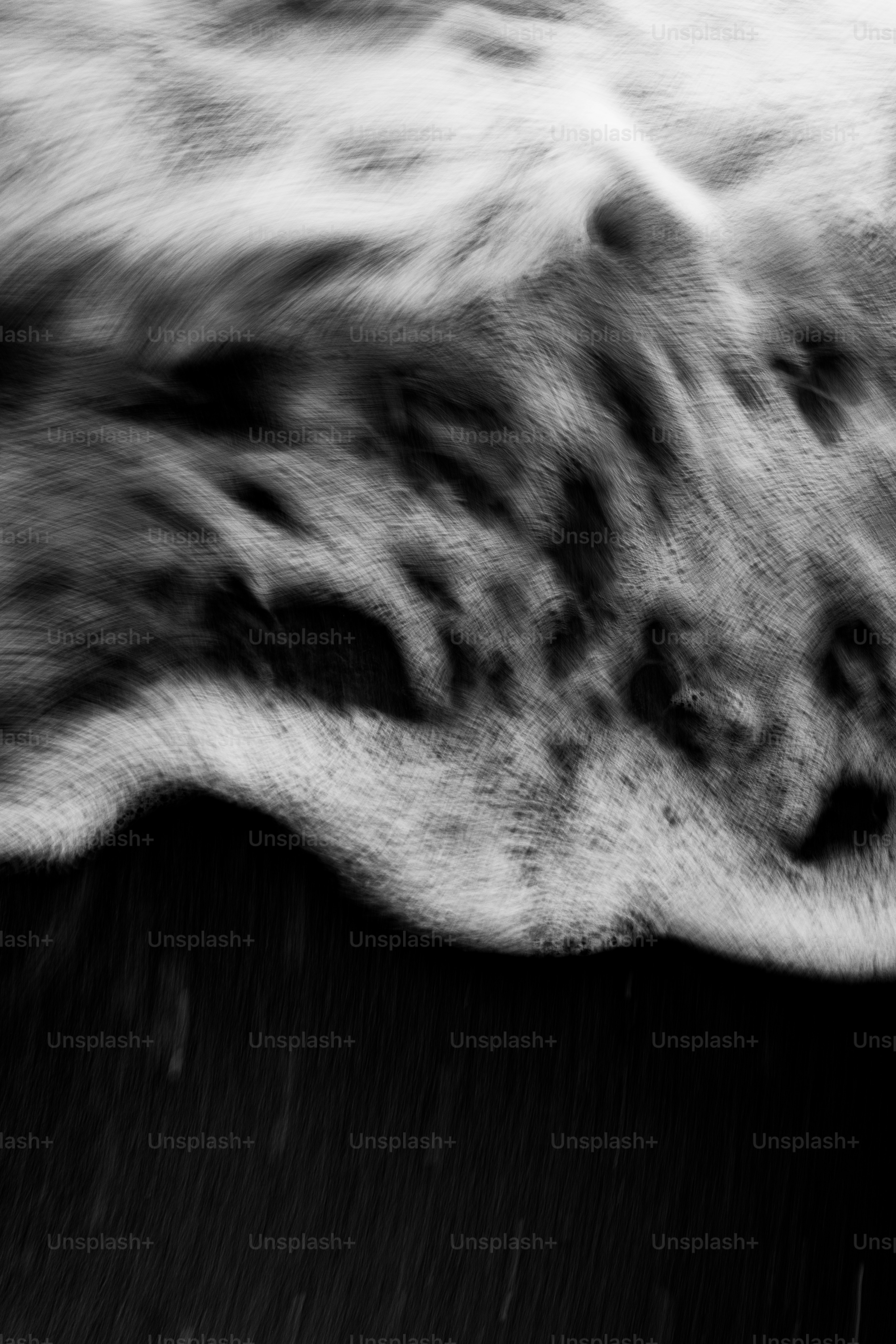 Gros plan d’une vague océanique écumante s’écrasant sur le sable noir