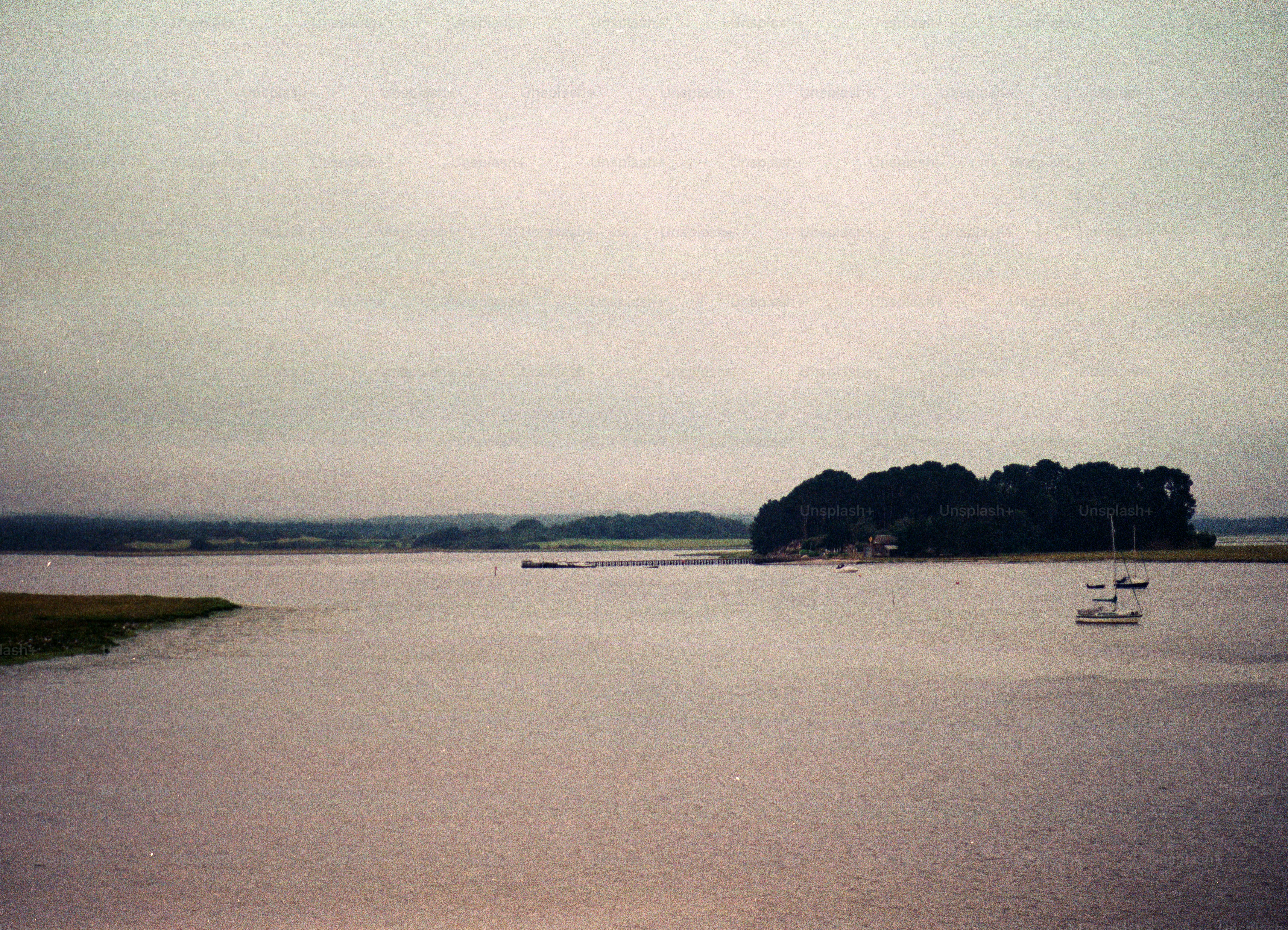 Calm water with a small island and sailboats