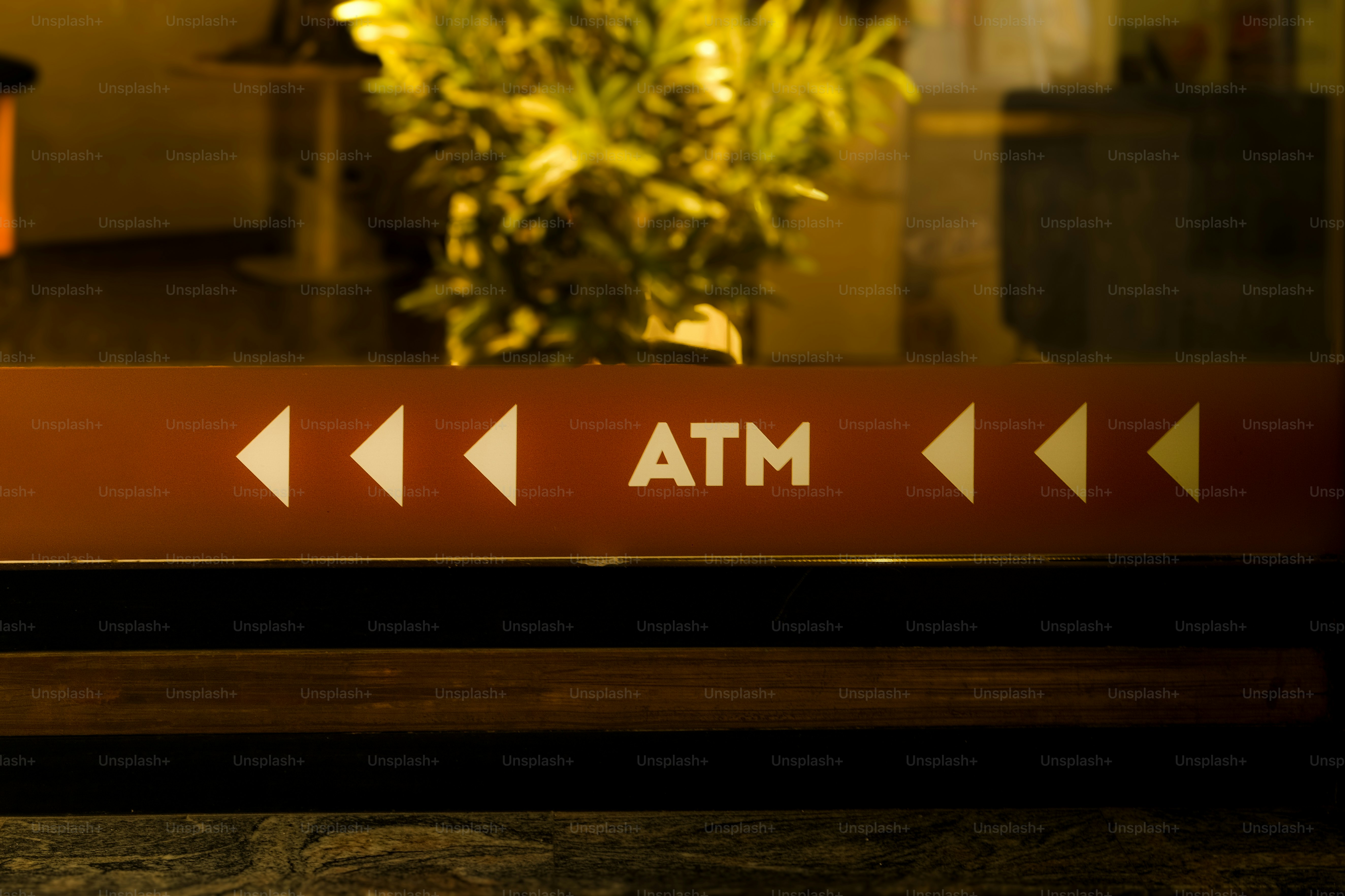 Brown sign with "atm" and white arrows.