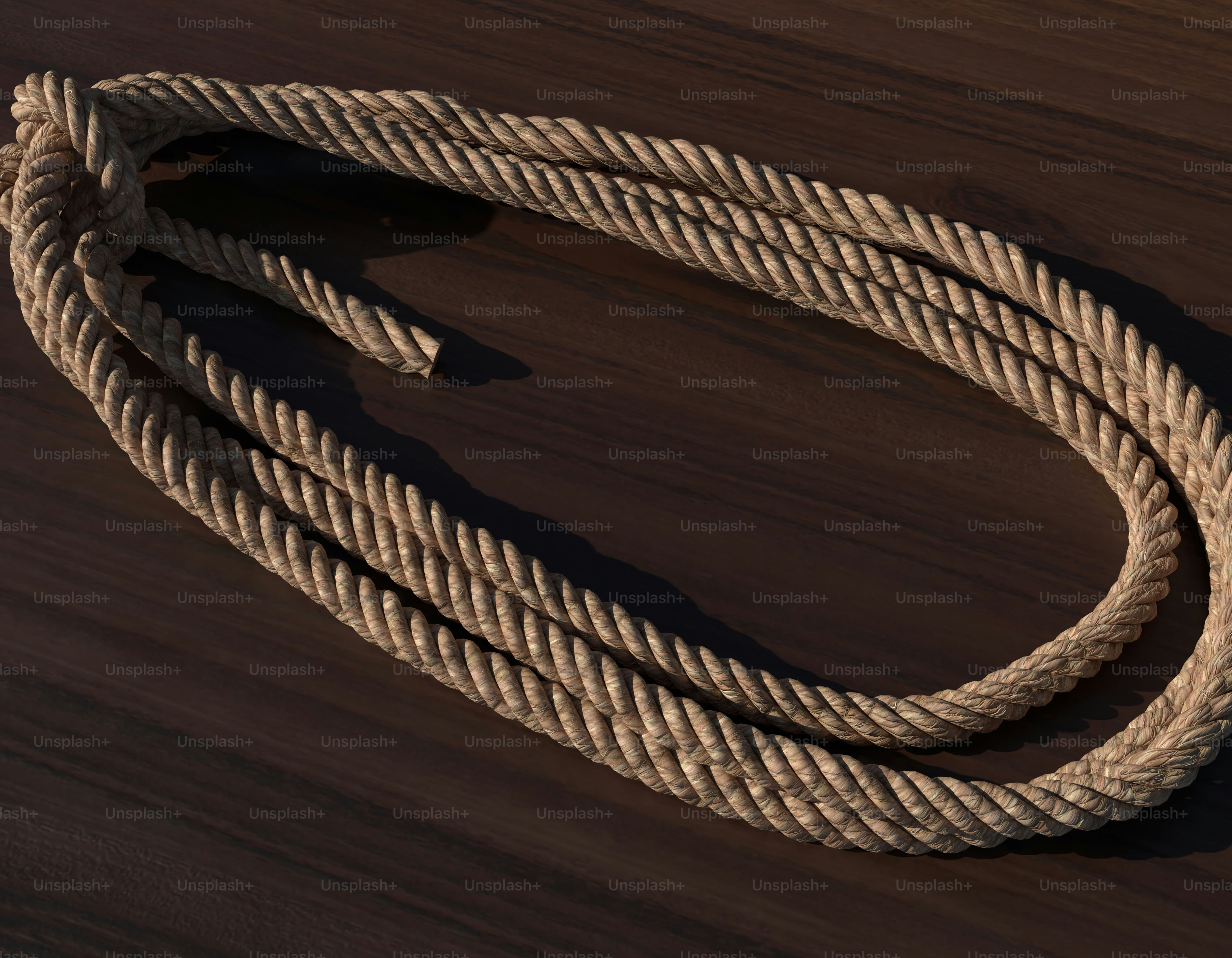 A thick rope lies coiled on a wooden surface. photo – Abstract Image on ...