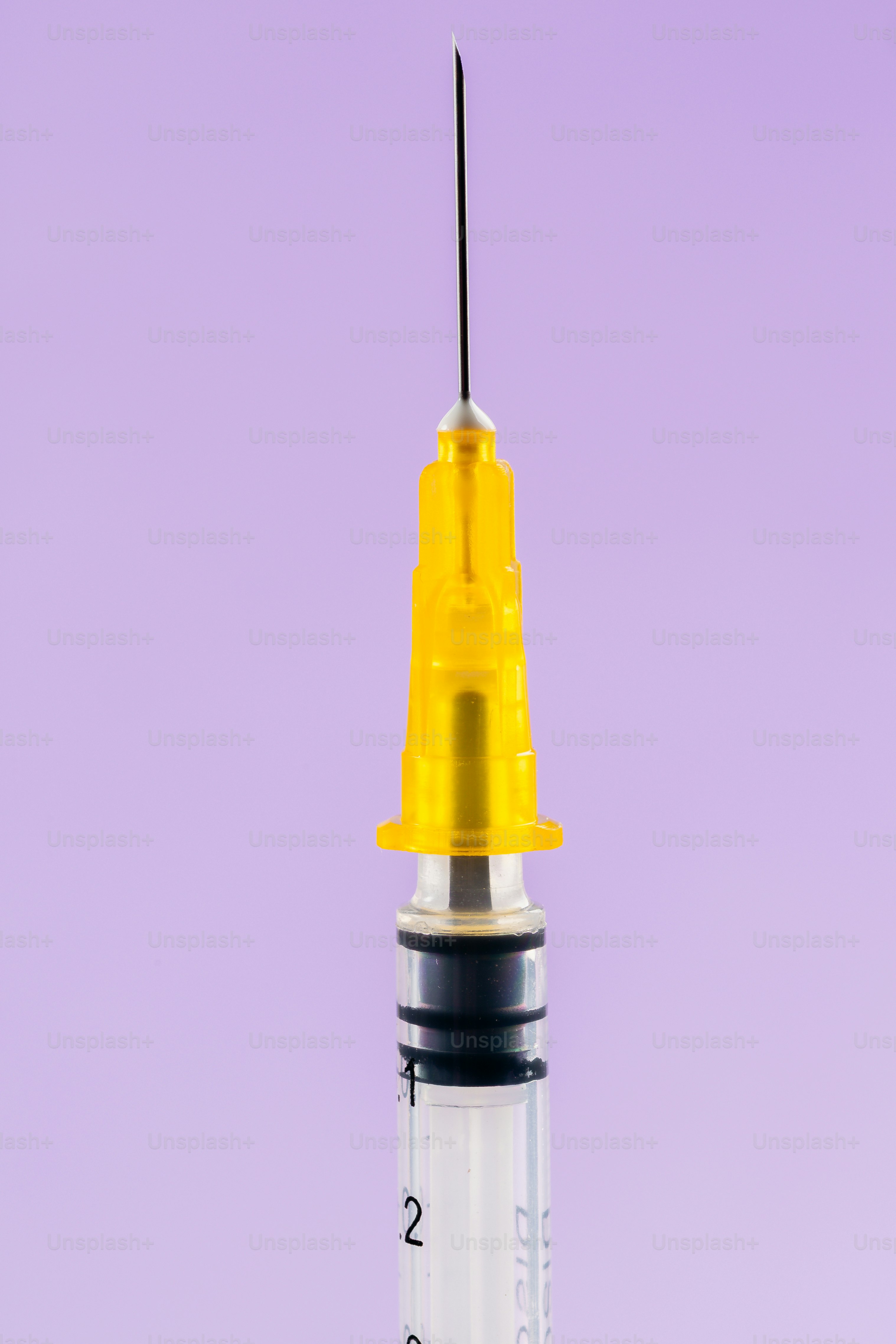 Close up of a medical syringe with yellow cap
