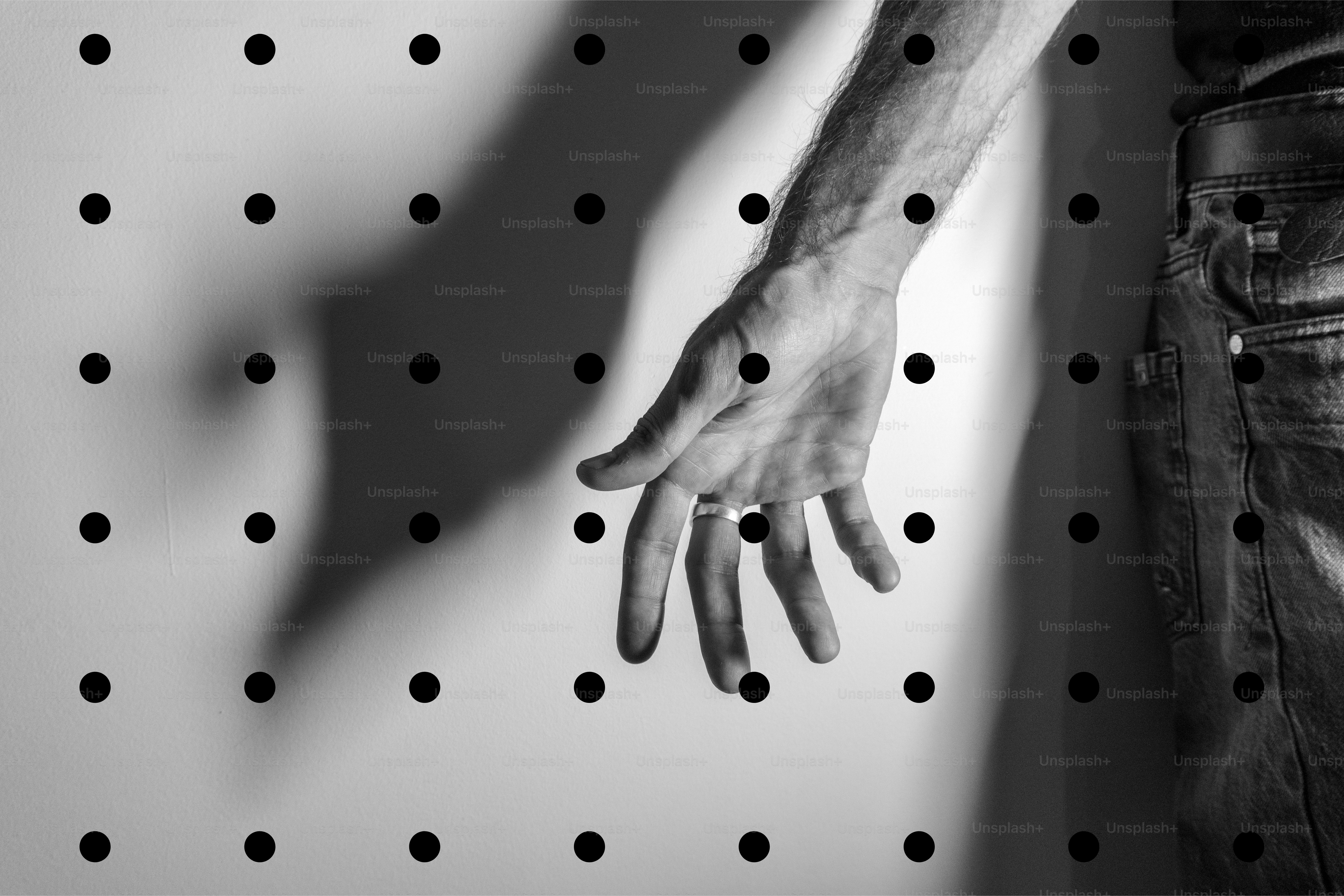 Man's hand reaching through dotted grid pattern