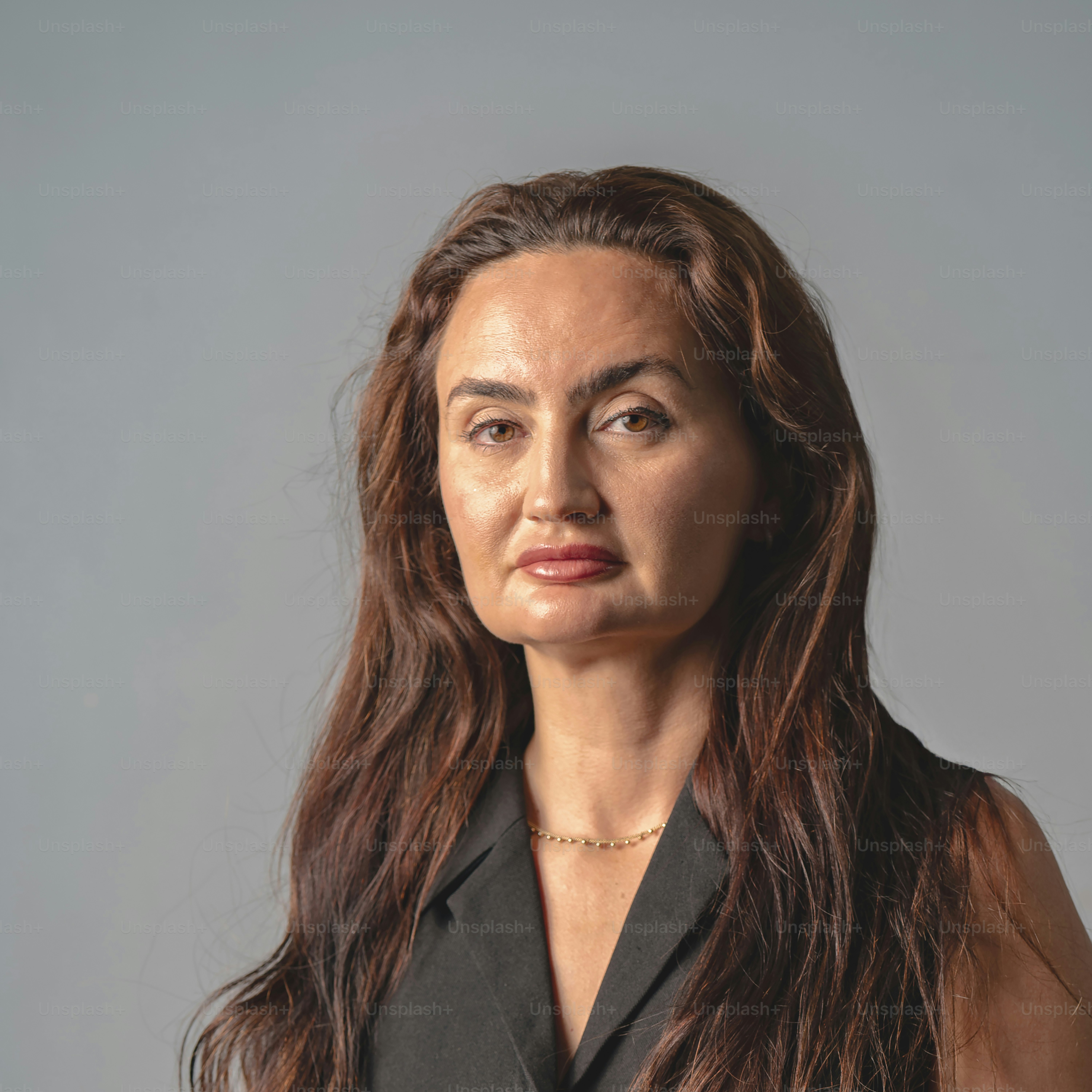 Uma mulher com longos cabelos castanhos vestindo um top preto.