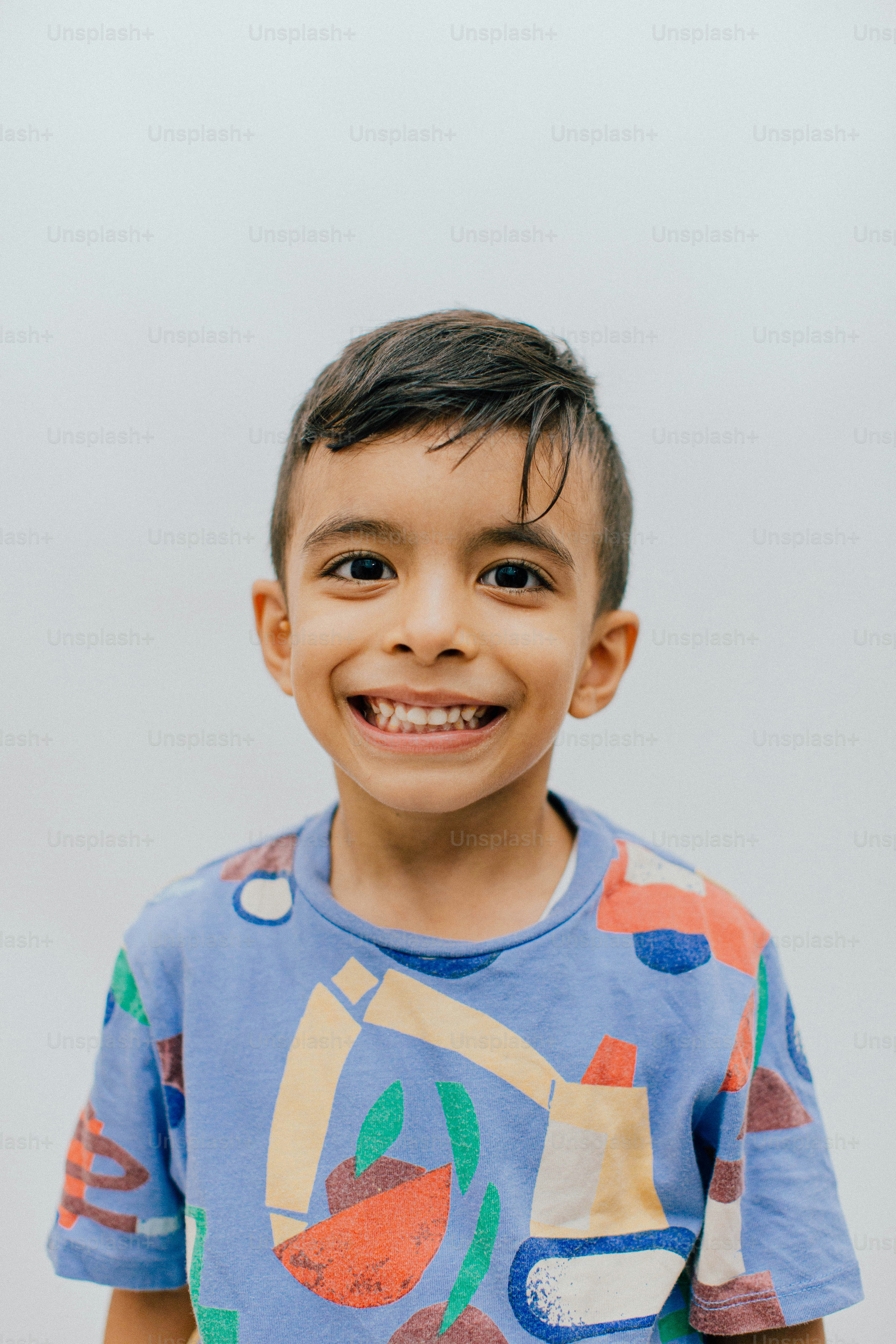 A young boy smiling with a colorful shirt