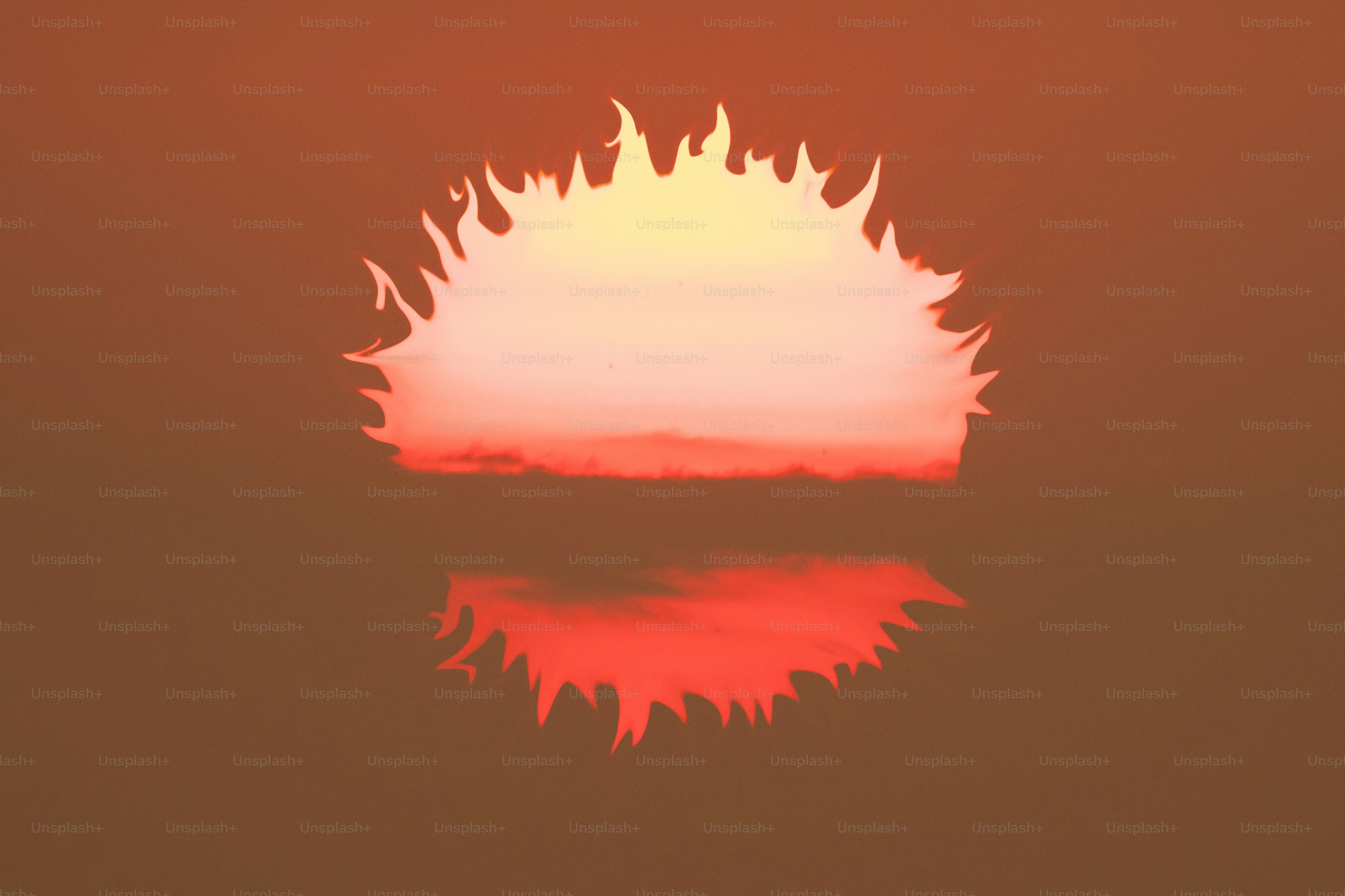 Sun setting over the ocean with fiery reflection