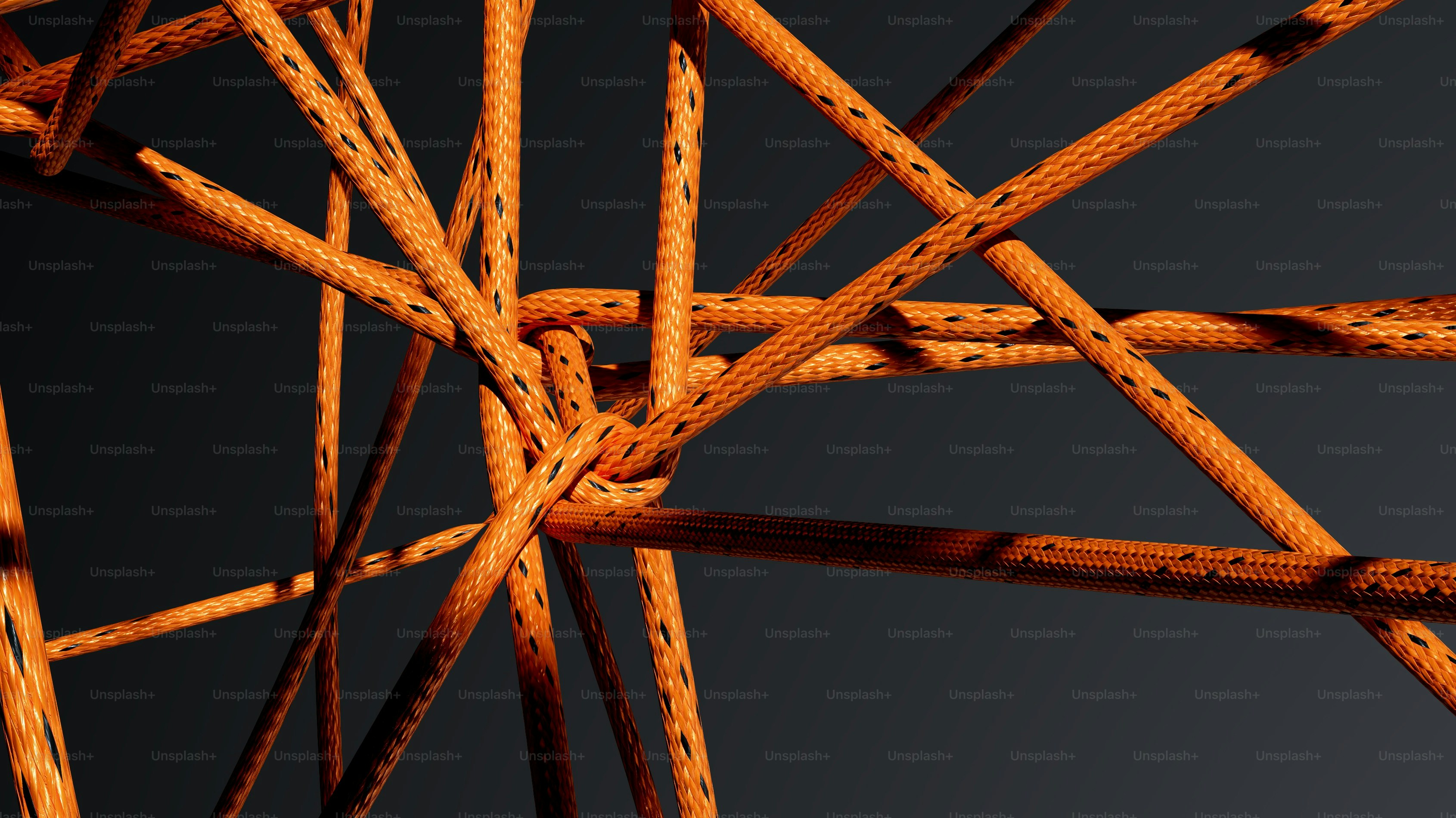 Intertwined orange ropes against a dark background photo – Abstract ...